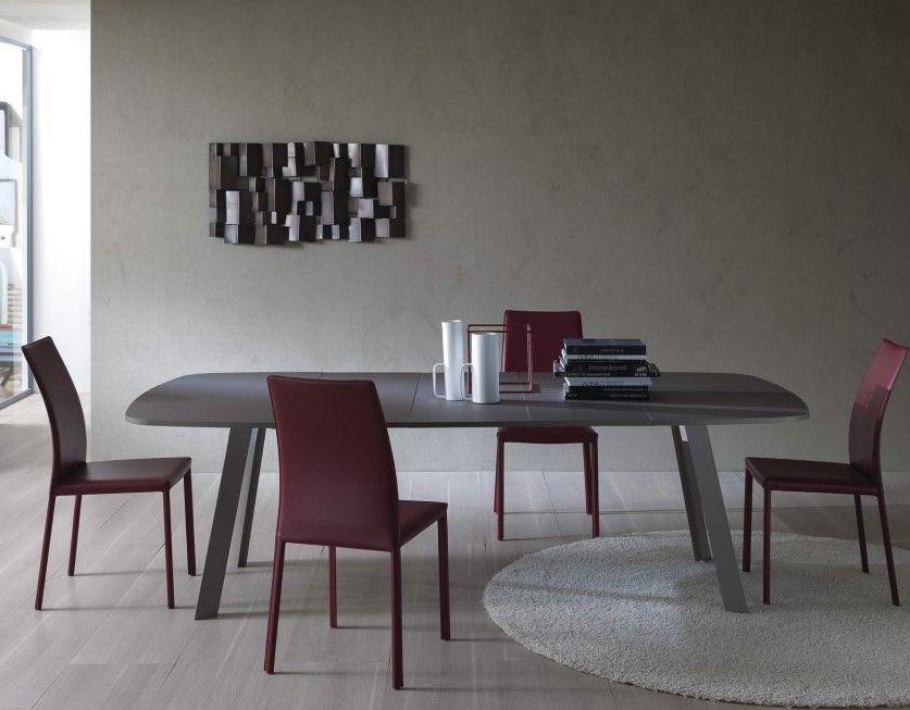 Una sala da pranzo con tavolo, sedie e un dipinto sul muro