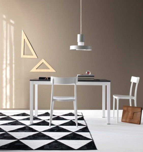 Una stanza con un tavolo, sedie e un tappeto