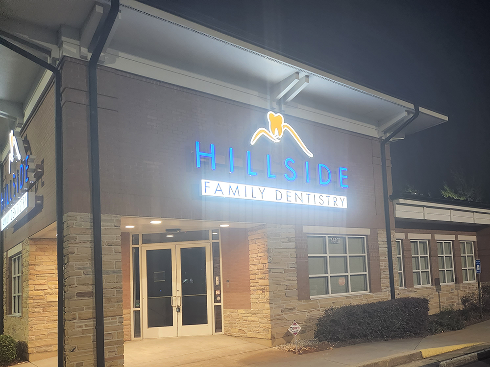 Hillside Family Dentistry outside of the building with lights on illuminating the sign