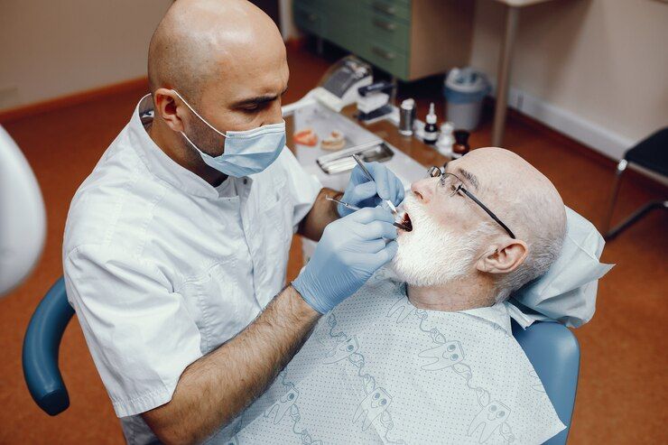 A dentist is examining a patient 's teeth in a dental office.