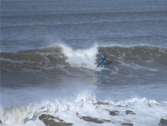 Surfer catching a nice wave at Westward Ho! North Devon. Ho! Surf faces this and can see it all happening out of the window.