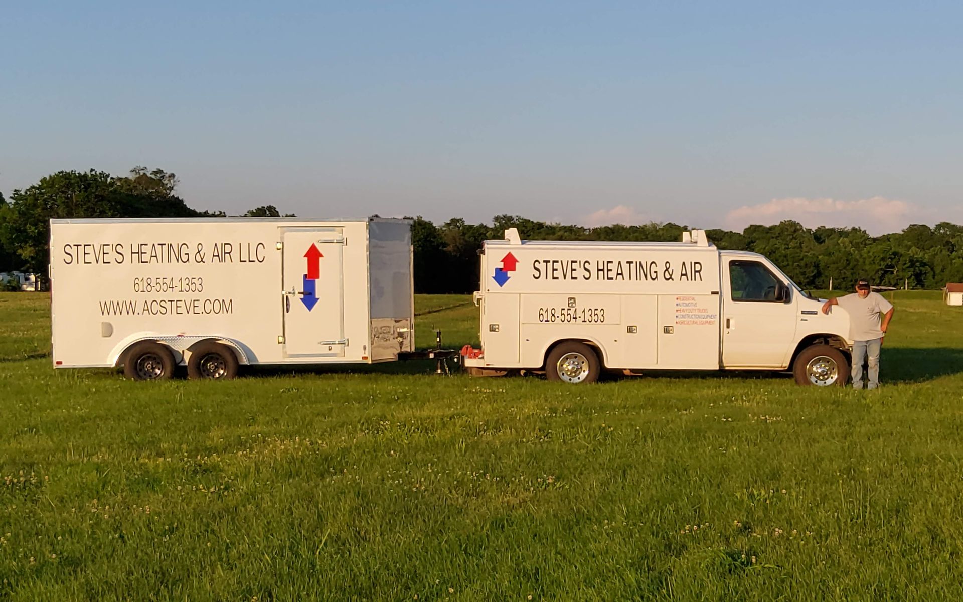 White service truck and trailer on grass field with heating and air logo.