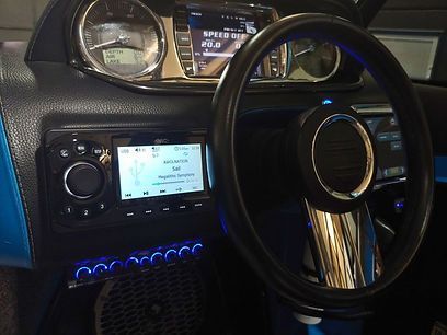 A close up of a steering wheel and dashboard of a boat