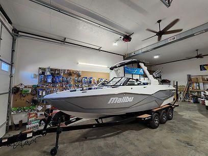 A boat is parked in a garage next to a garage door.