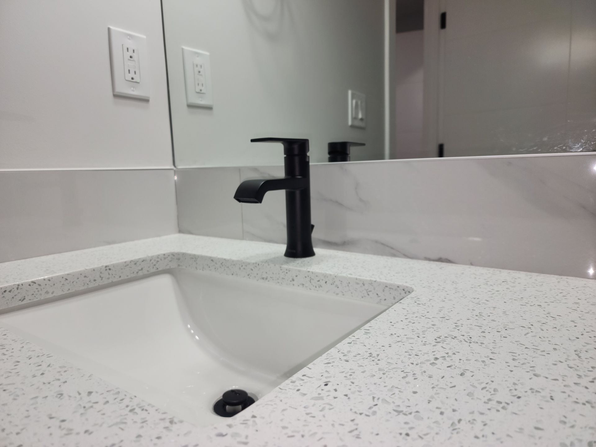 picture showing a vanity faucet and a quartz counter-top in a basement development 