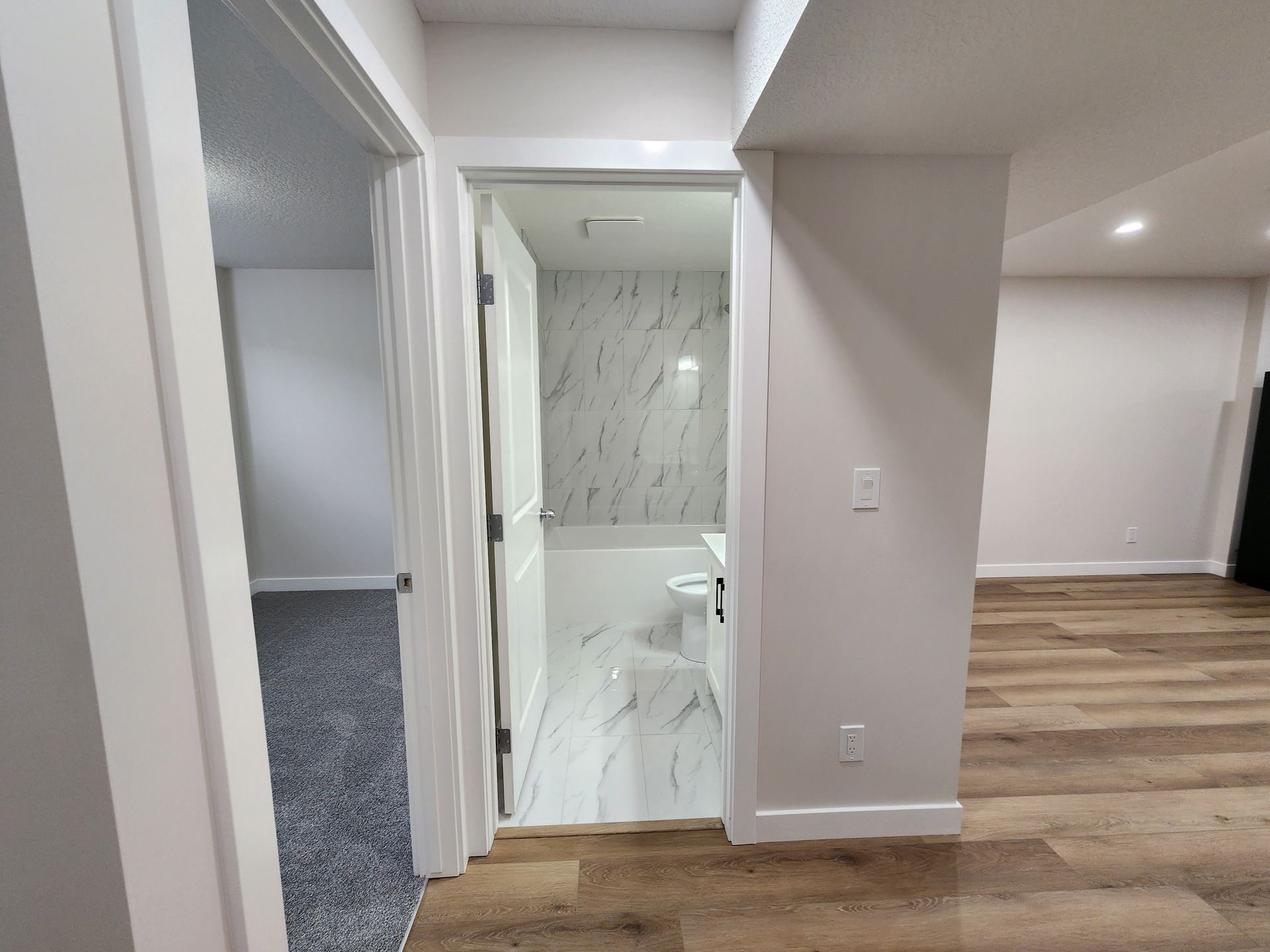 View of a basement leading to a tiled bathroom and Vinyl flooring in a developed Calgary home