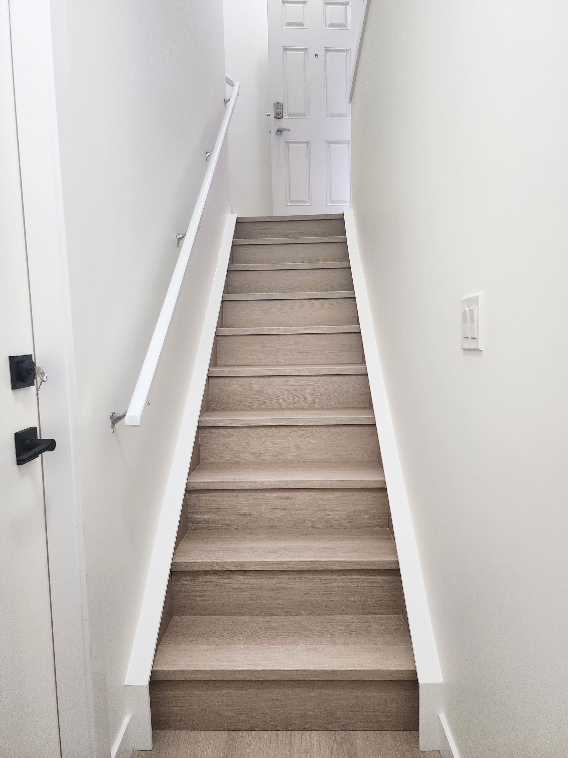 Image shows a beautifully finished Vinyl stair case in a basement project in Calgary Alberta