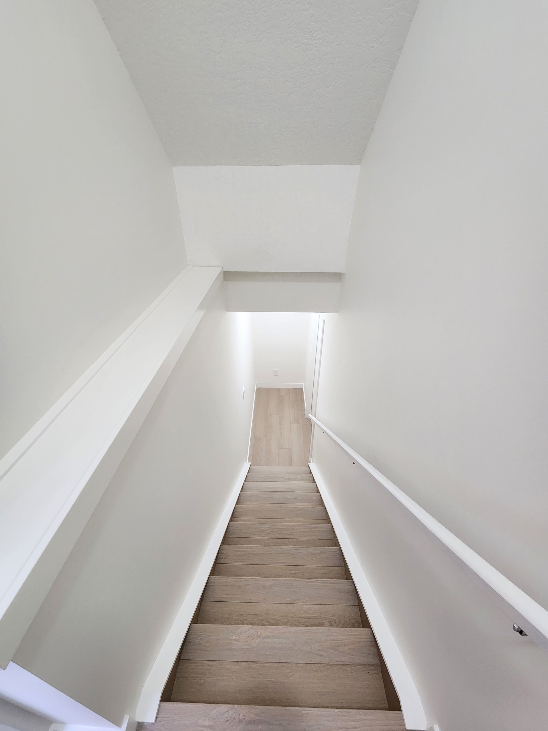 Image shows a precise finished luxury Vinyl Plank Staircase leading to a Legal basement suite