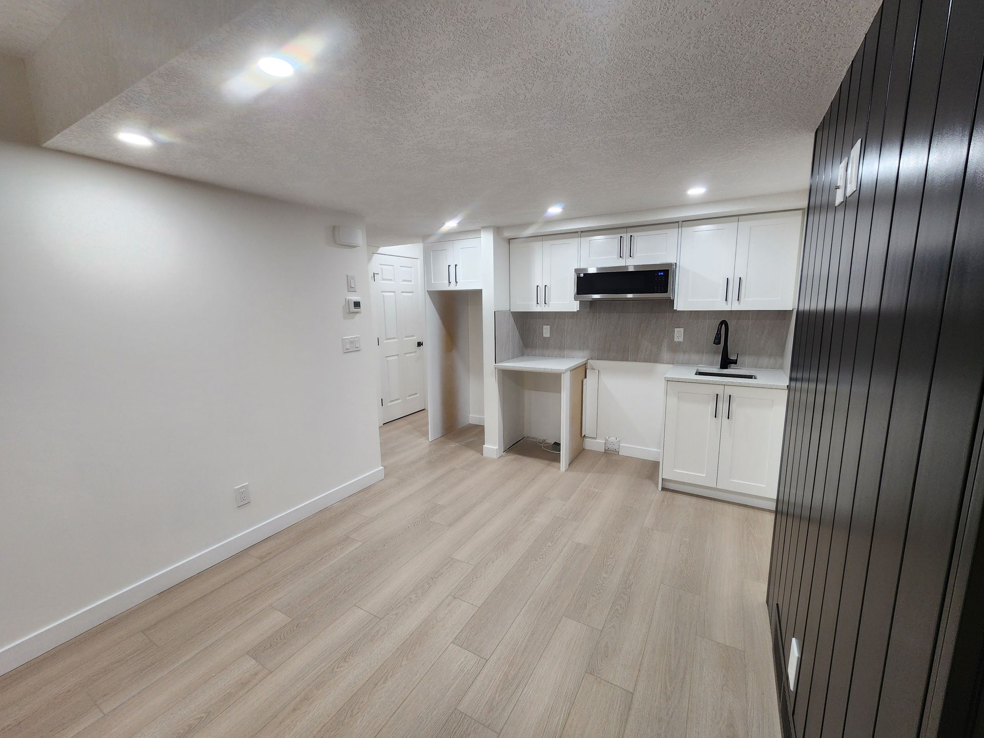 picture shows a painted grade shaker style kitchen in a finished basement renovation in Calgary