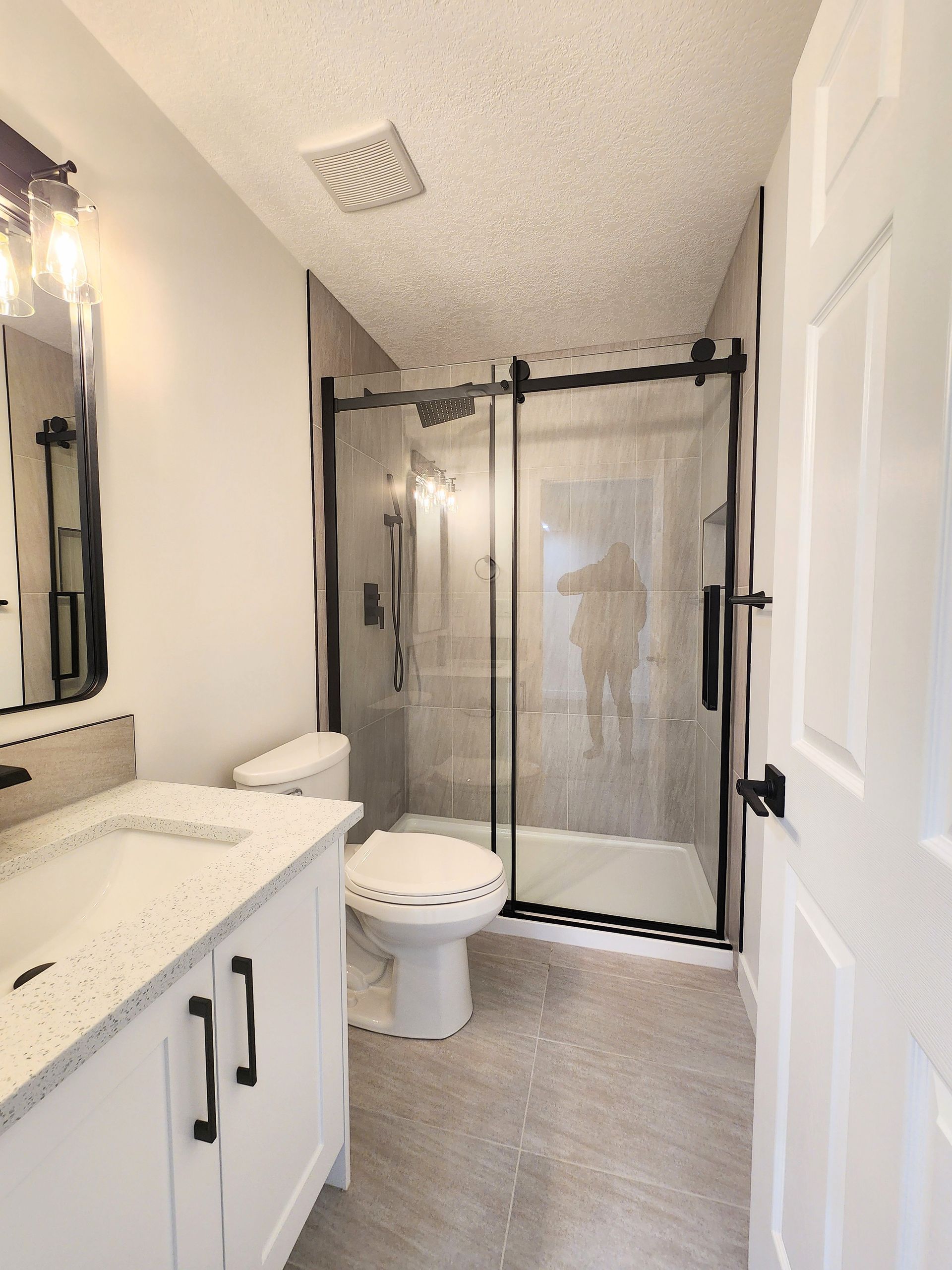 this is lose up image of a beautiful shower with sliding glass in a finished basement renovation in Calgary