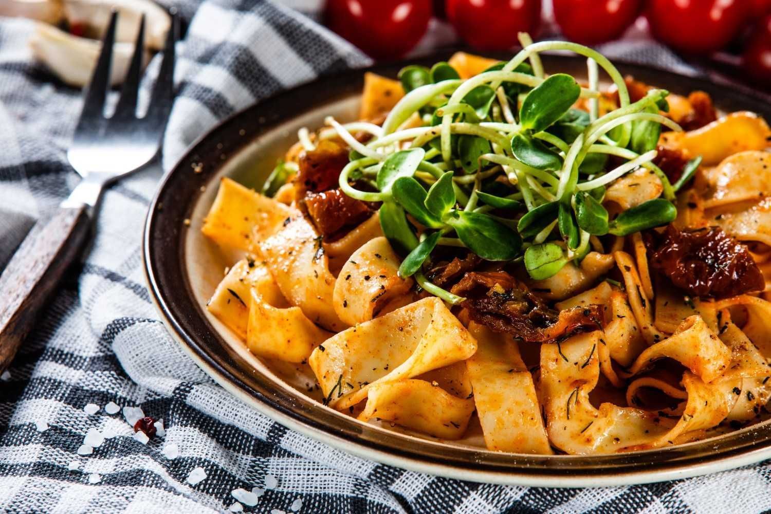 Pasta Dish with Sun Dried Tomatoes and Sprouts — Romanas Italian Restaurant in Nobby Beach, QLD