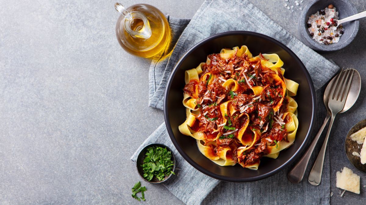 Pasta Dish with Meat Sauce in A Black Bowl — Romanas Italian Restaurant in Nobby Beach, QLD