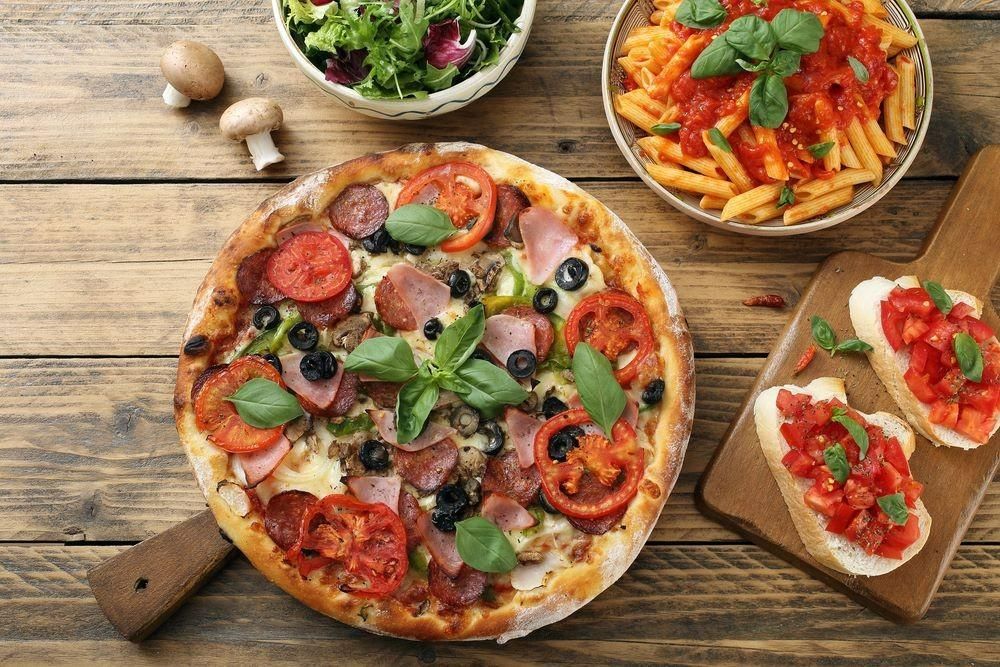 Pizza Topped with Tomatoes — Romanas Italian Restaurant in Nobby Beach, QLD