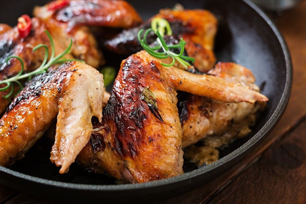 Close-Up of Cooked Chicken Wings in A Black Skillet — Romanas Italian Restaurant in Nobby Beach, QLD