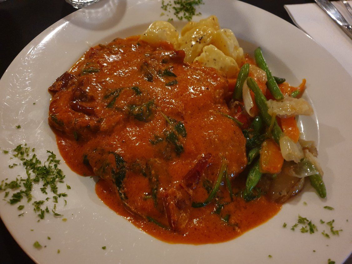 A Plate of Food With Meat and Vegetables on a Table — Romanas Italian Restaurant in Nobby Beach, QLD