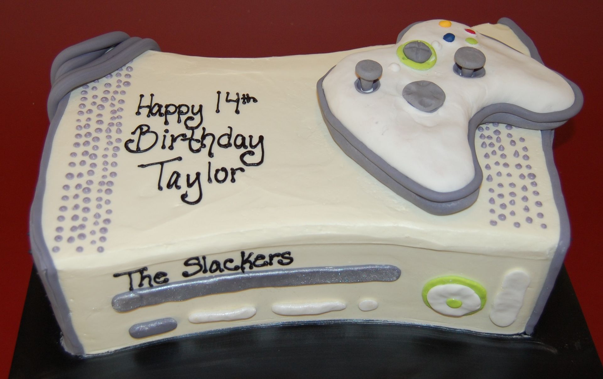 a cake that looks like a video game controller says happy 14th birthday taylor