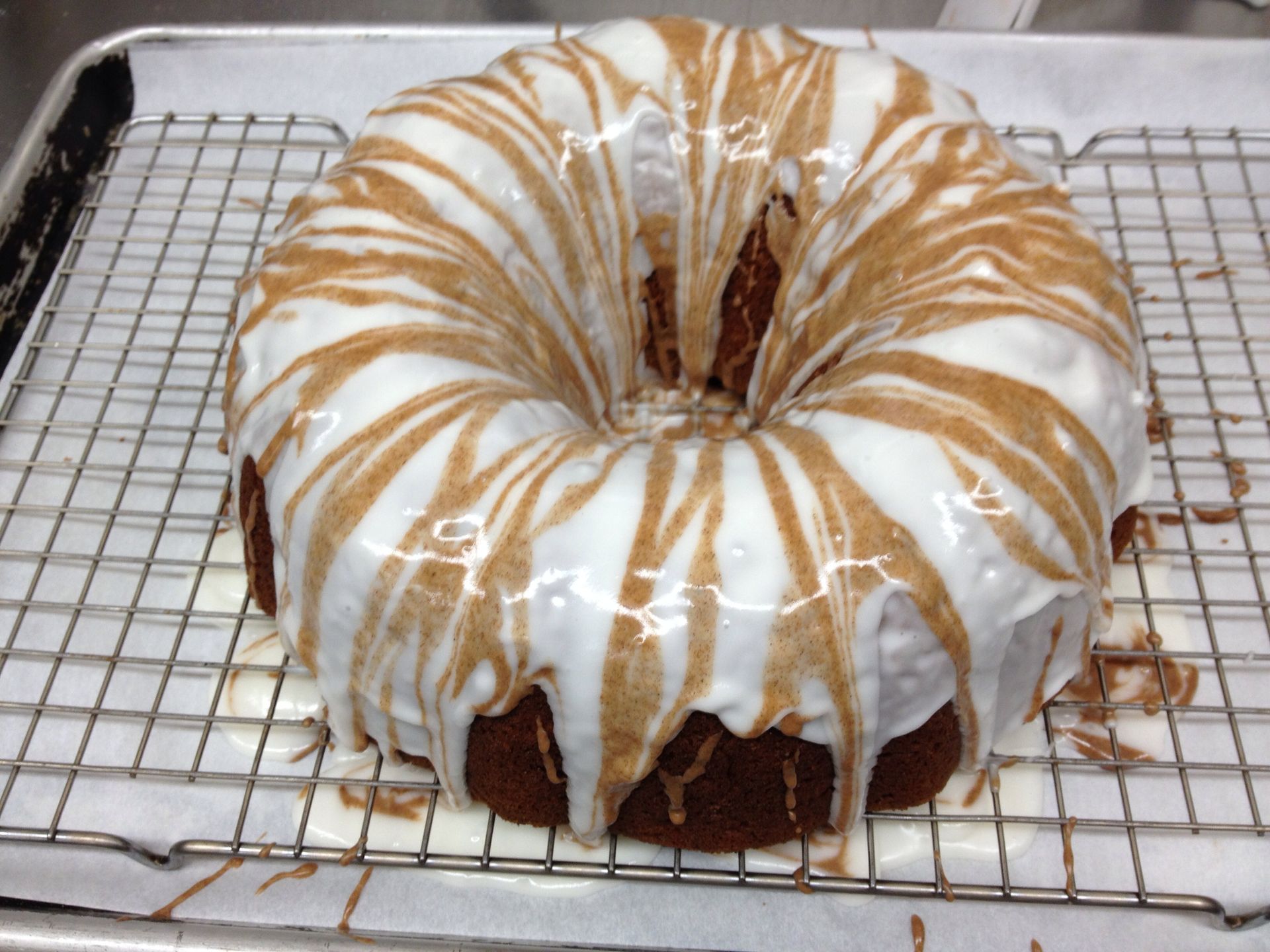 a bundt cake with white frosting and caramel swirls