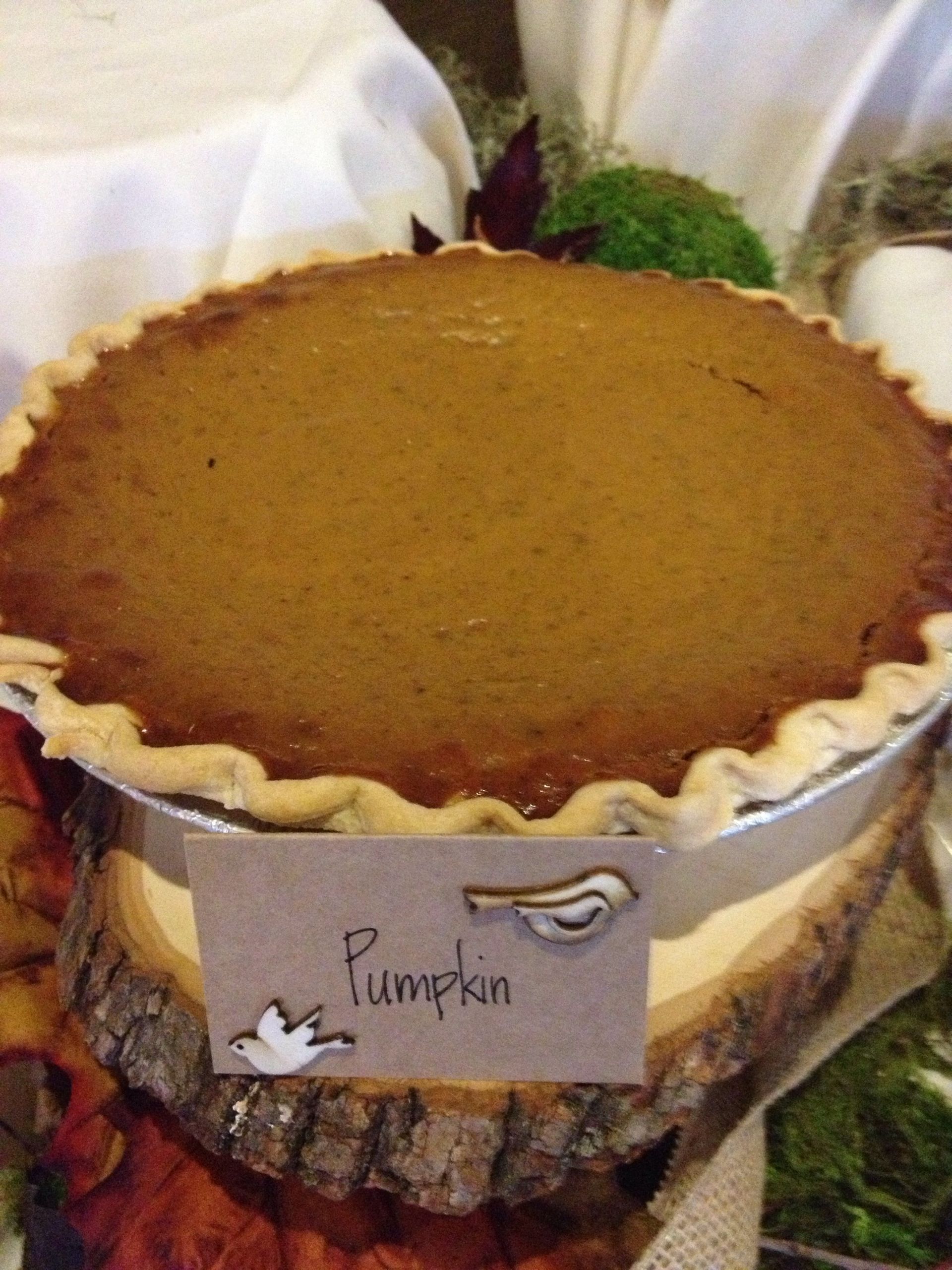 a pumpkin pie is sitting on top of a wooden table .
