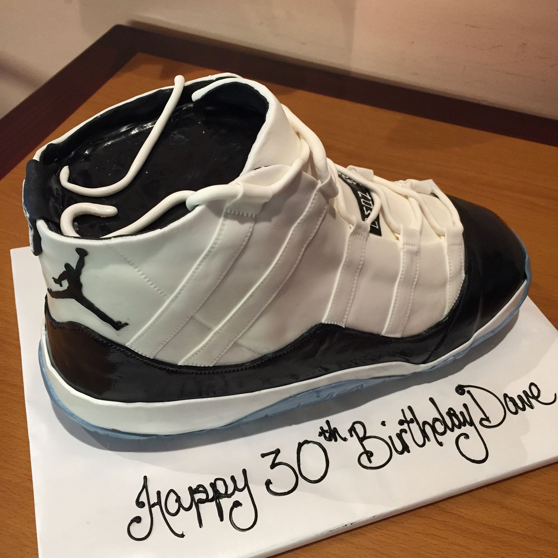 a cake in the shape of a shoe says happy 30th birthday dave