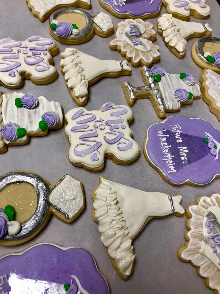 a bunch of bridal shower cookies with purple frosting