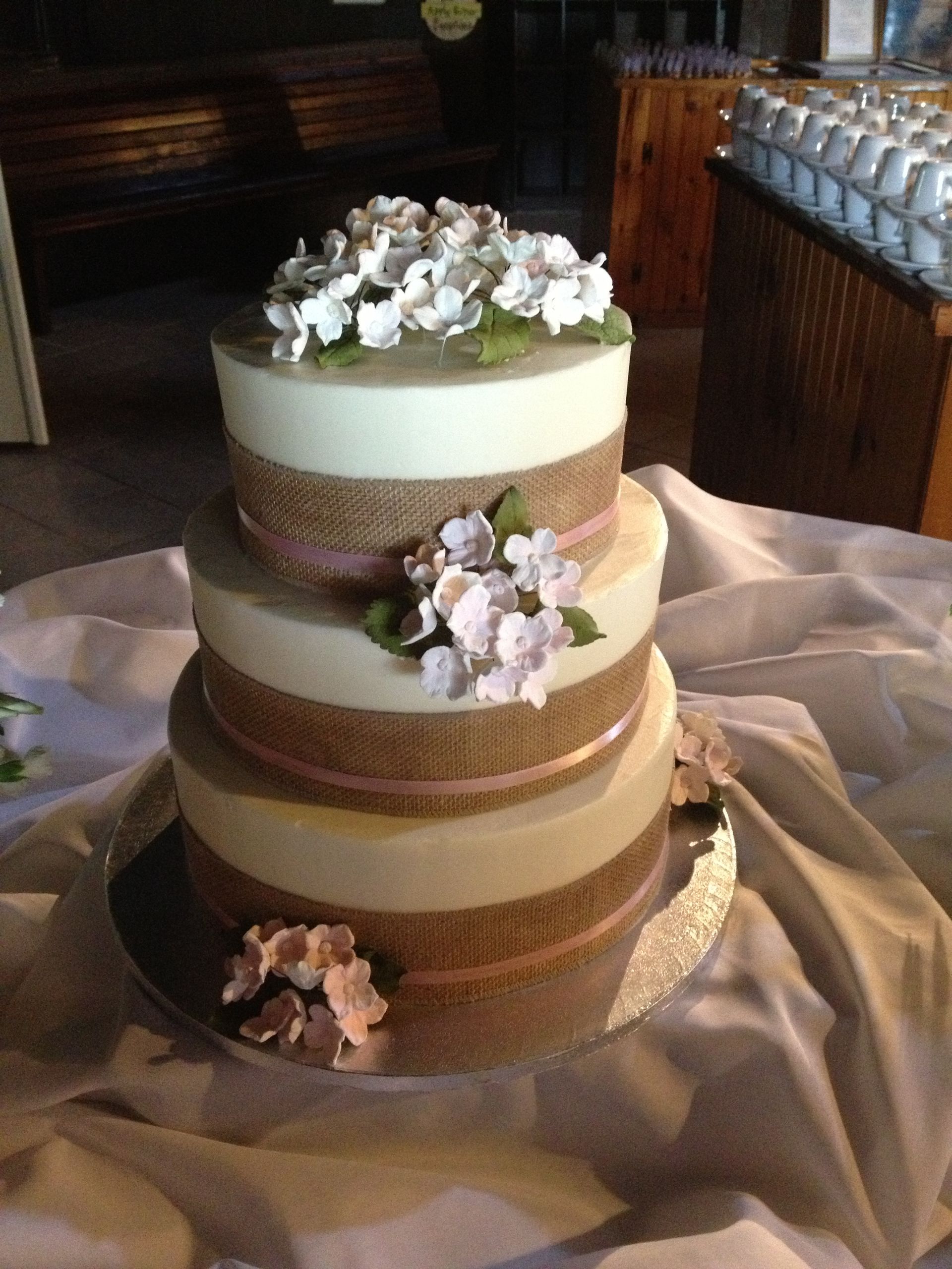 a wedding cake with flowers on top is on a table