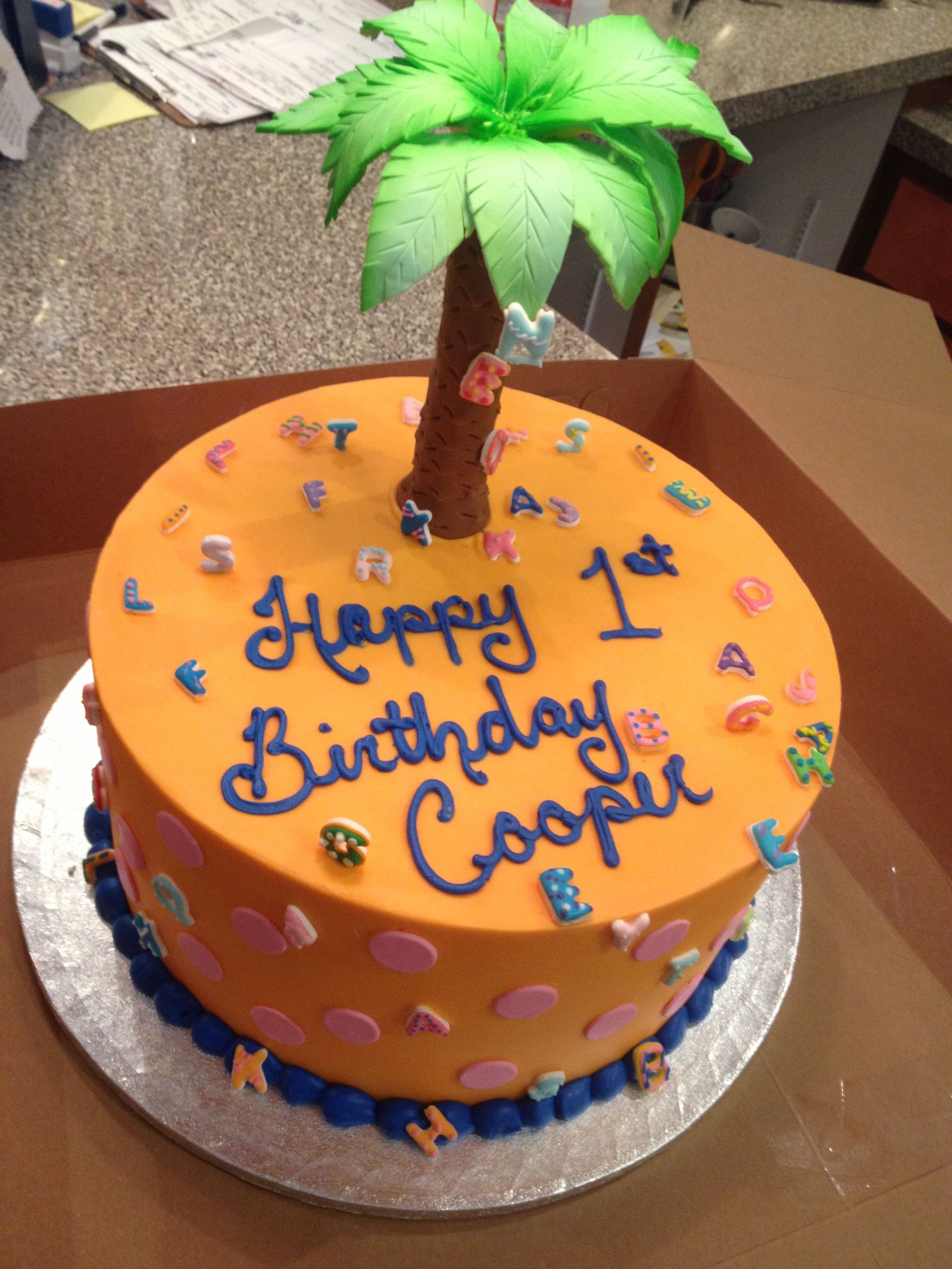 a 1st birthday cake with a palm tree on top