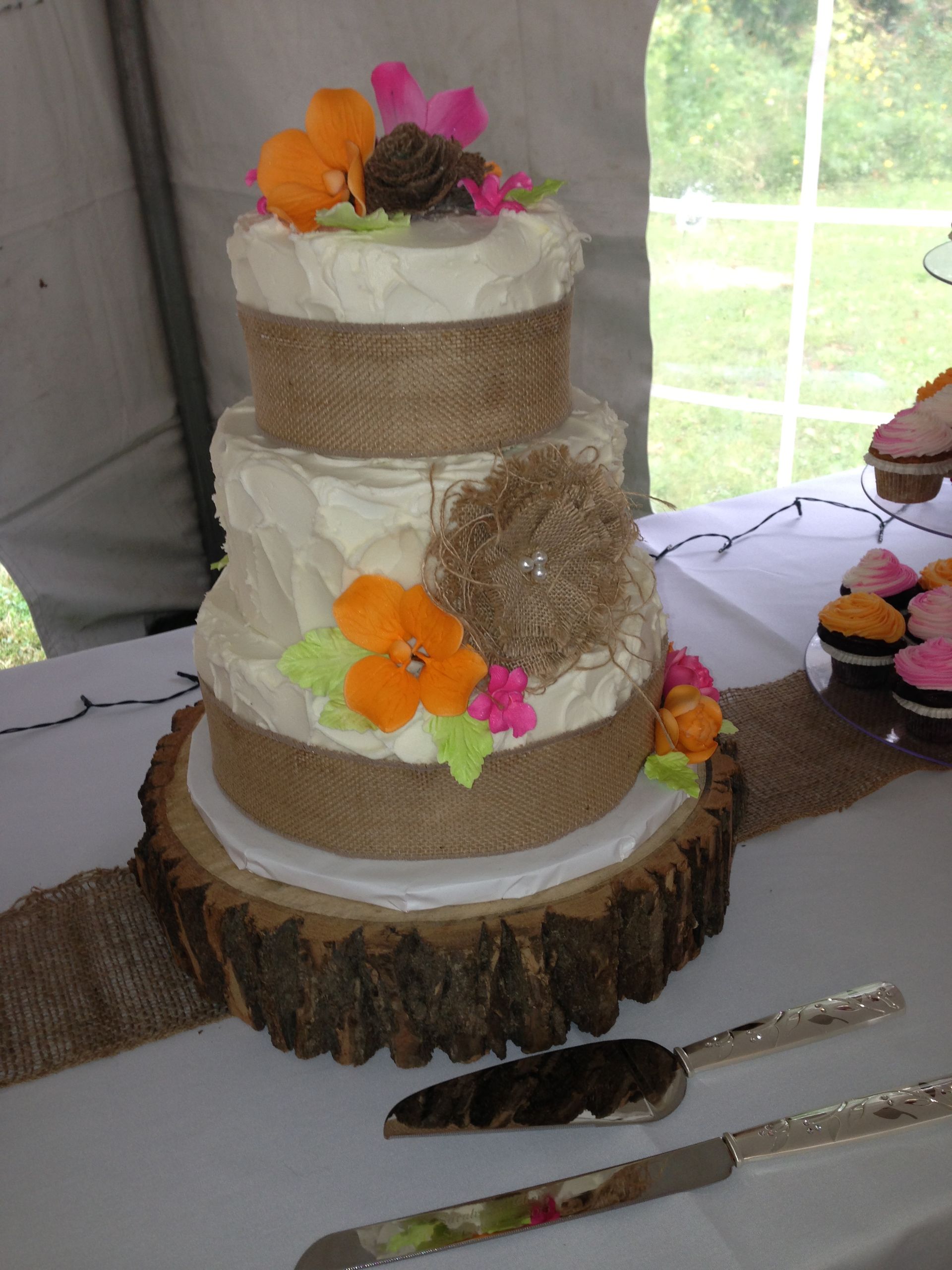 a wedding cake sitting on top of a tree stump
