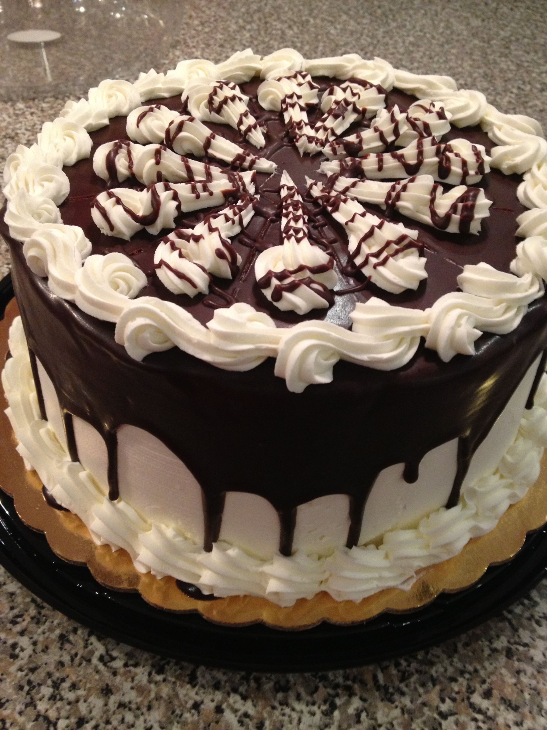 a cake with chocolate frosting and whipped cream on top