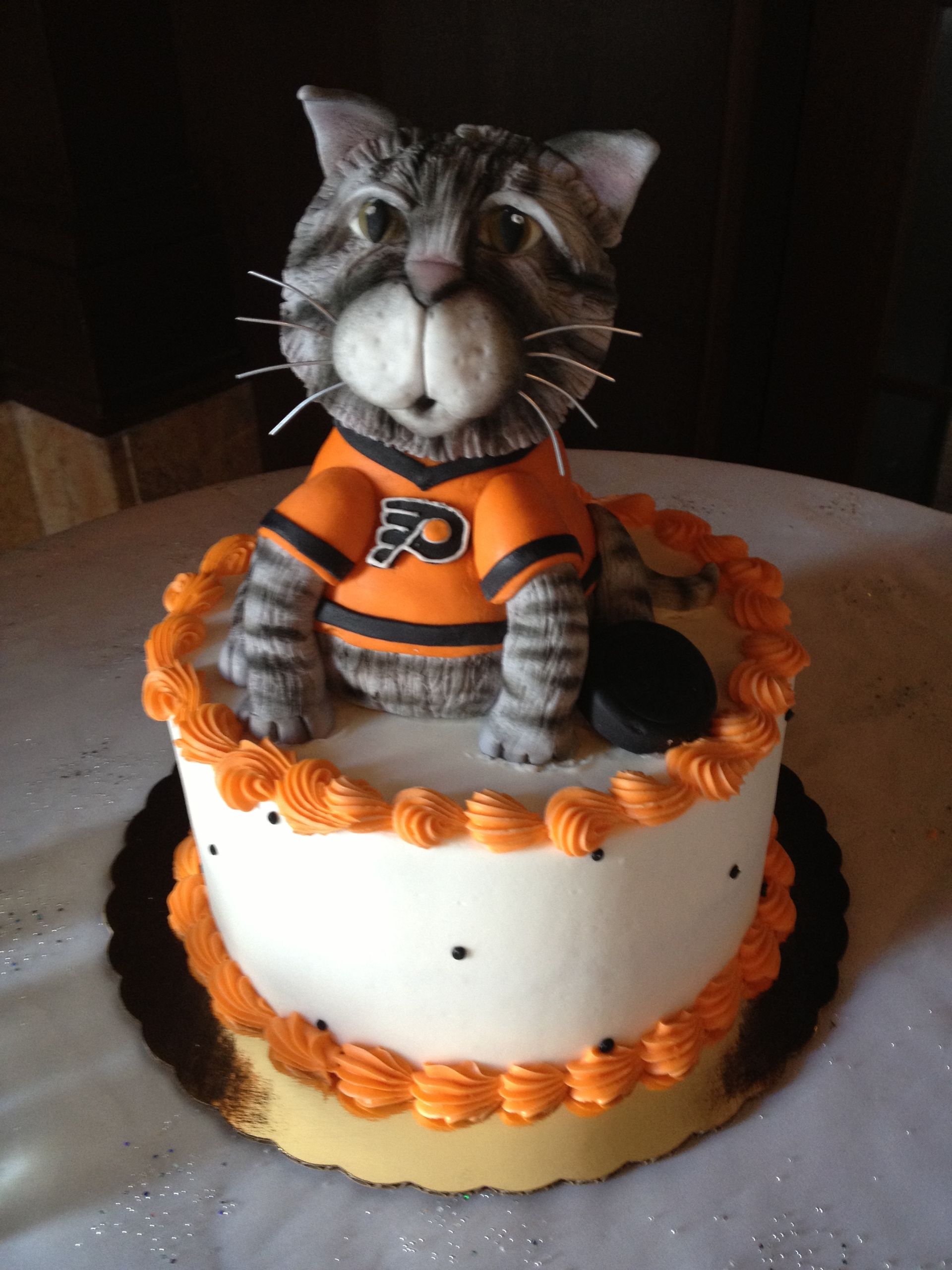 a philadelphia flyers cake with a cat on top