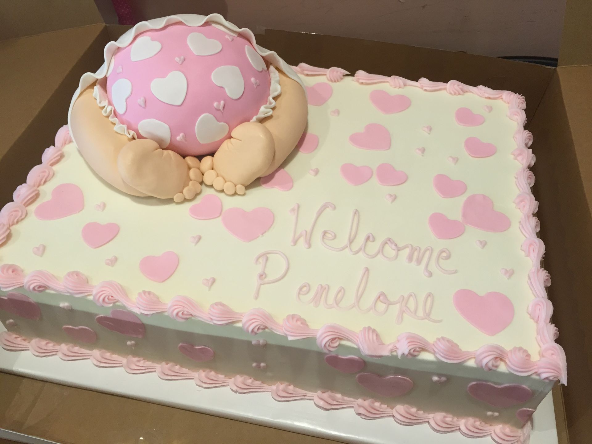 a baby shower cake with a baby laying on top of it .