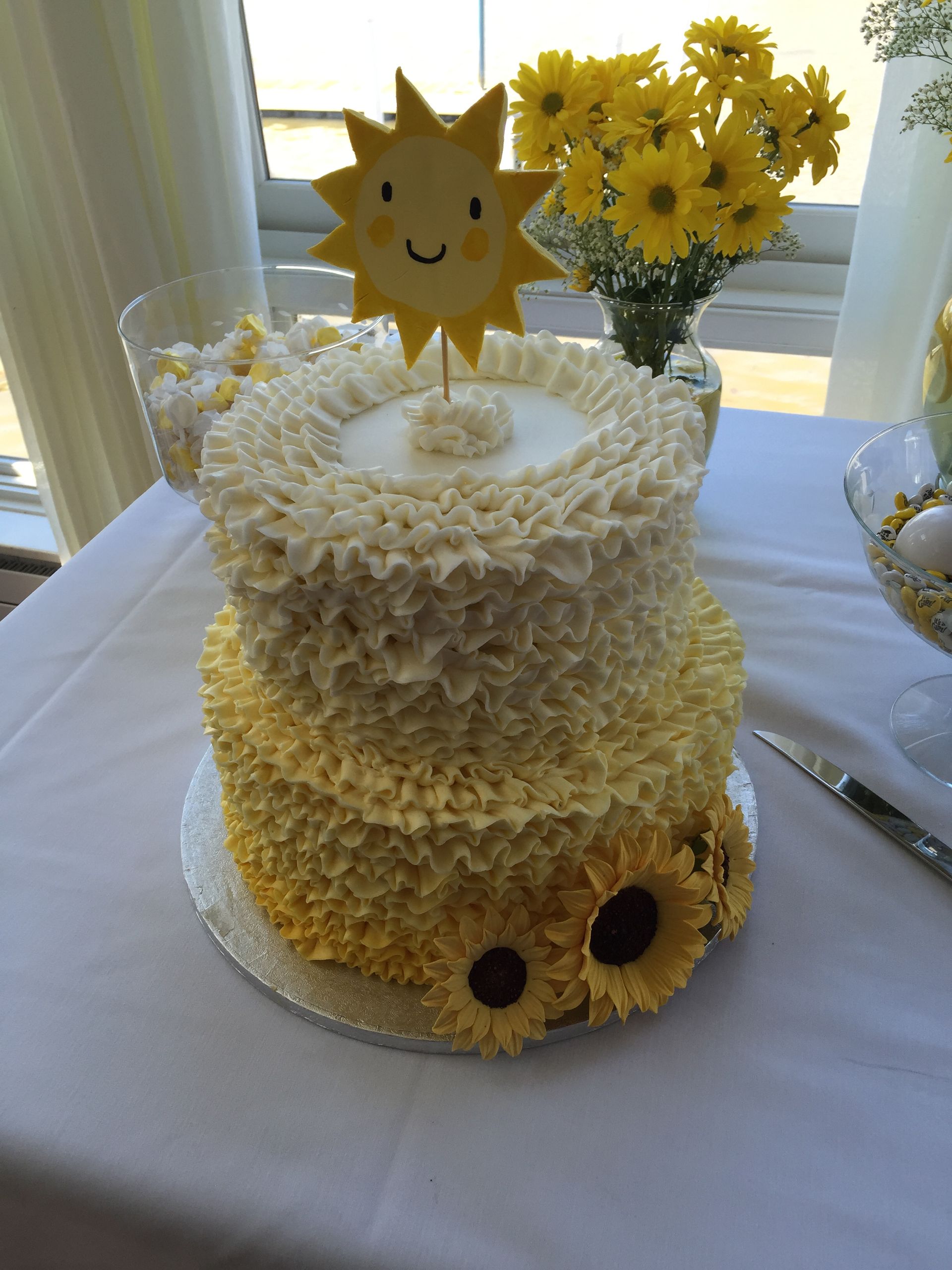a cake with a sun on top of it is on a table .