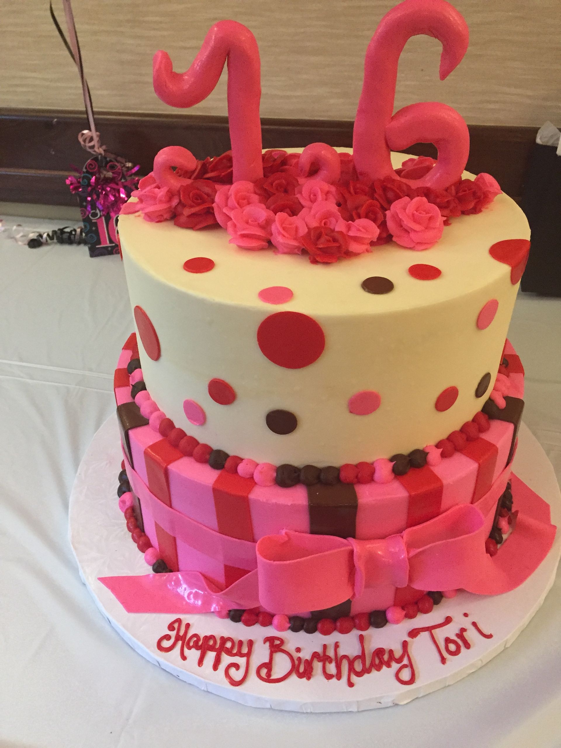 a pink and white birthday cake with the number 16 on top