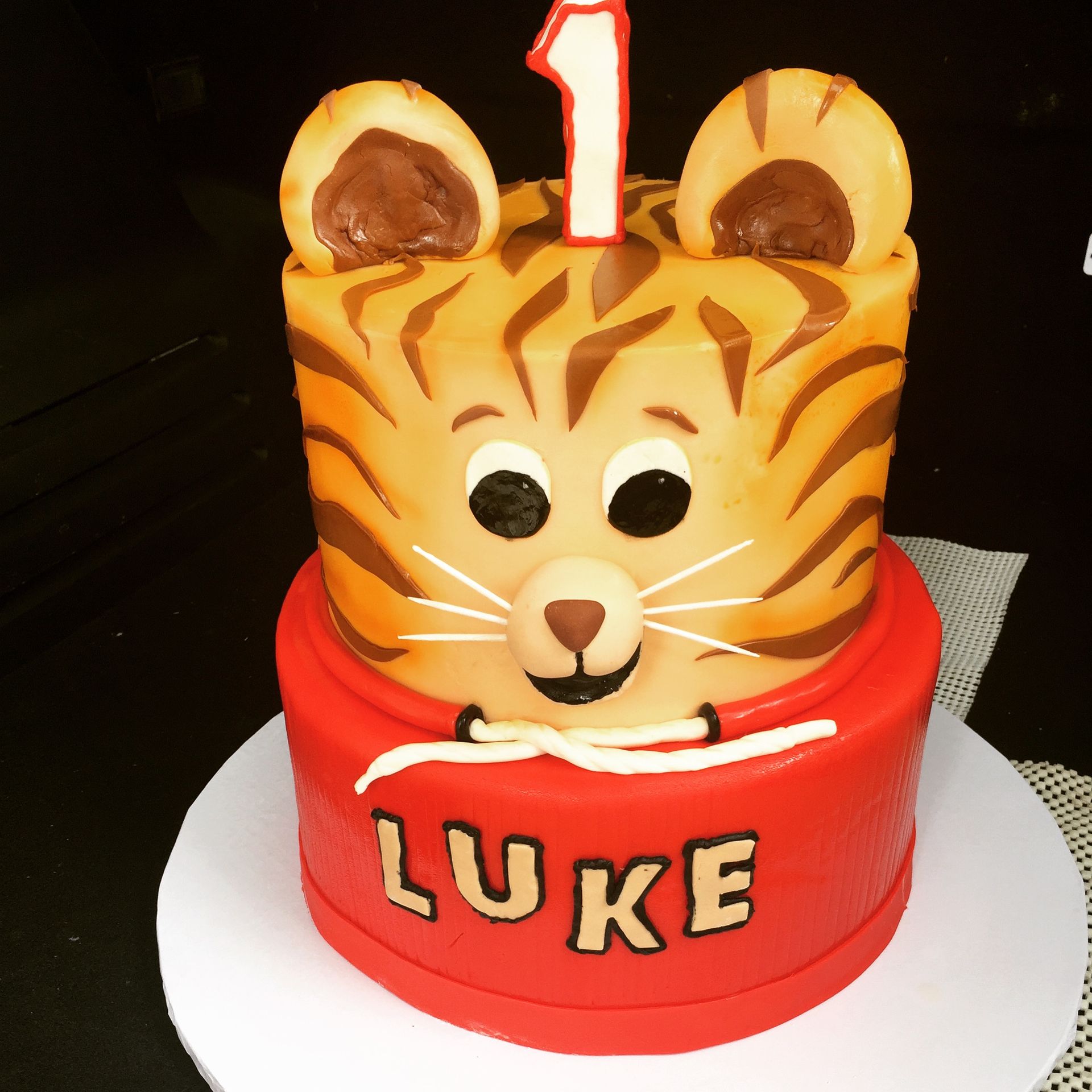 a cake with a tiger face and the name luke on it