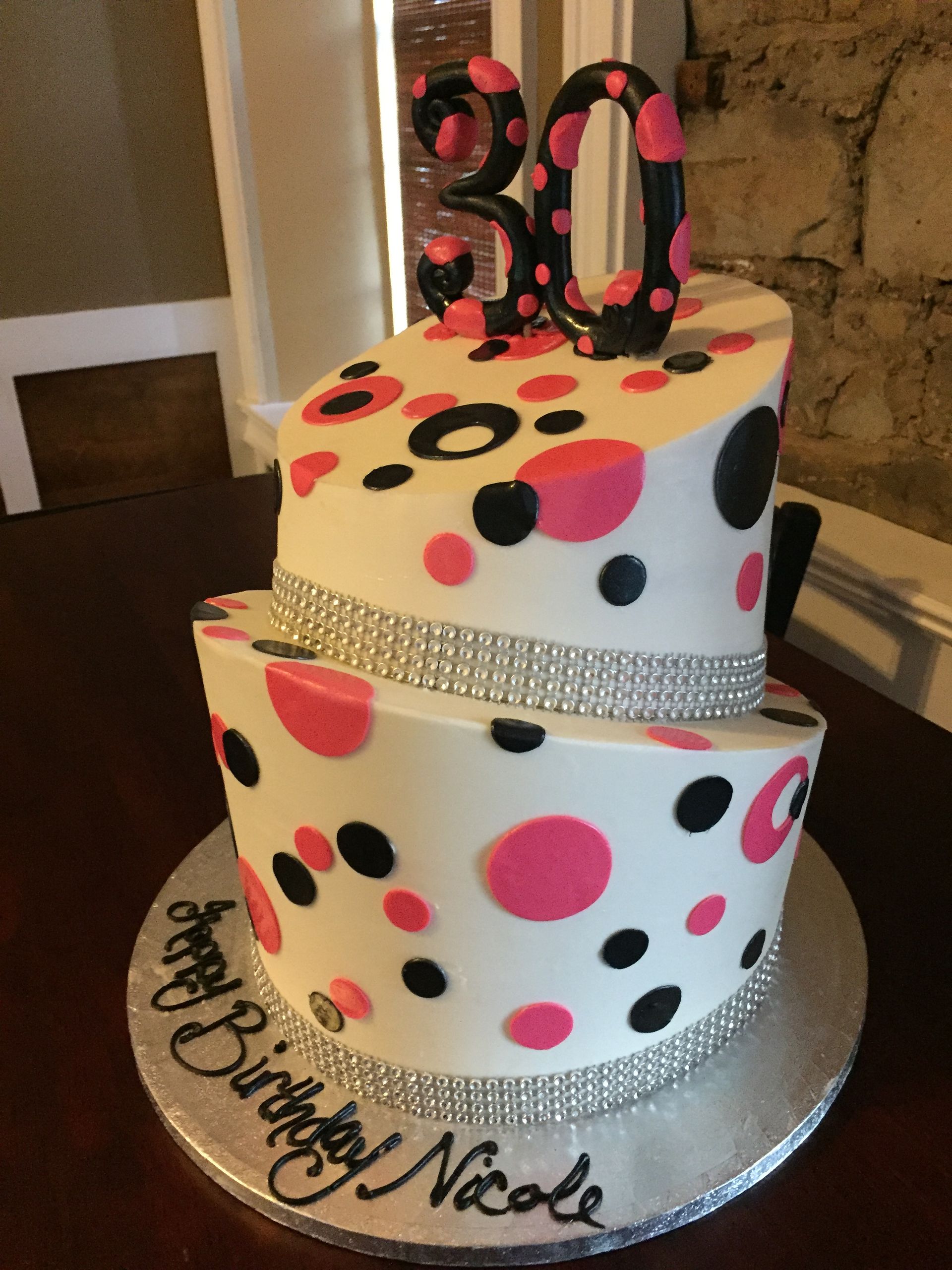a birthday cake with pink and black polka dots and the number 30 on top