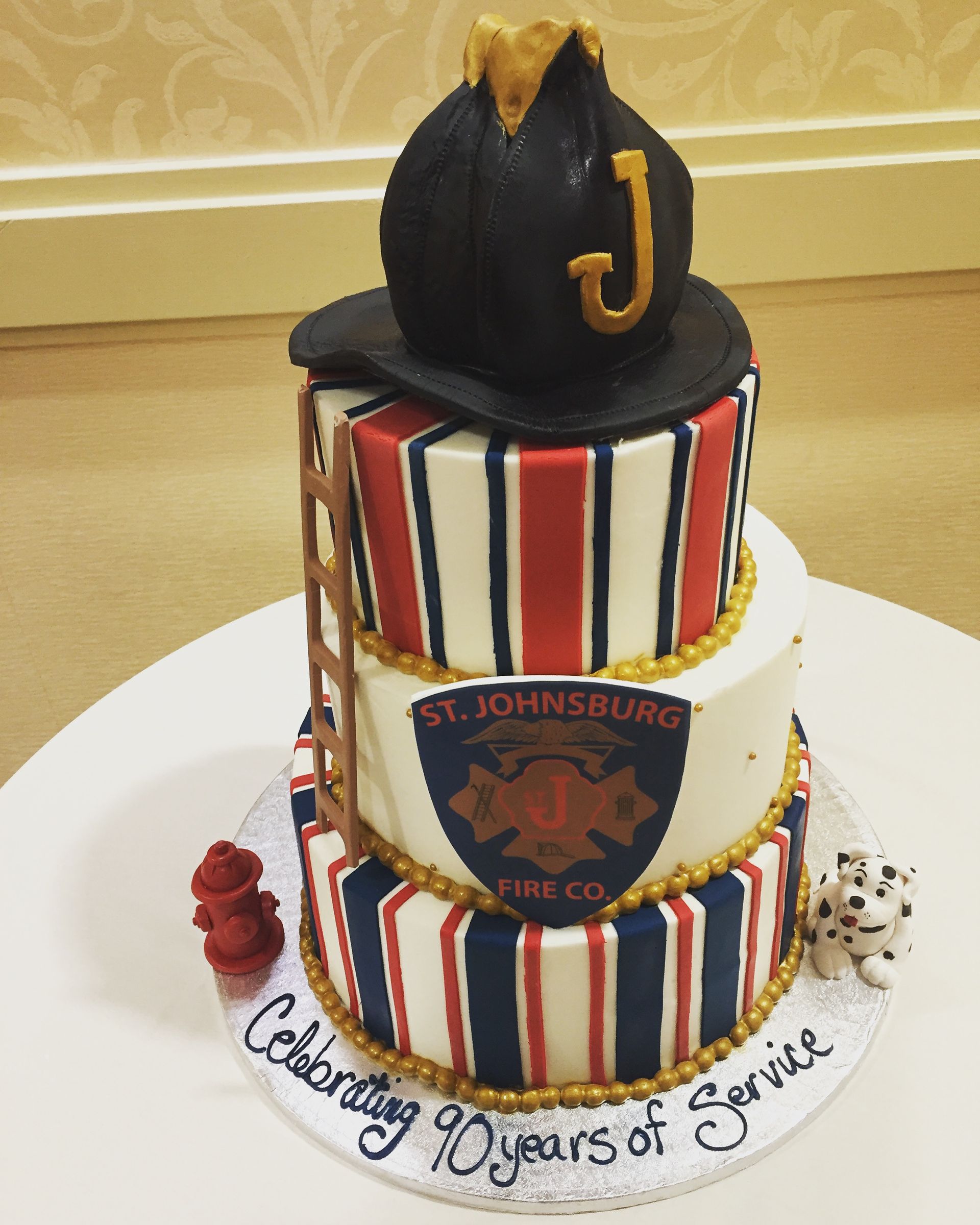a cake with a fireman 's helmet and the letter j on top