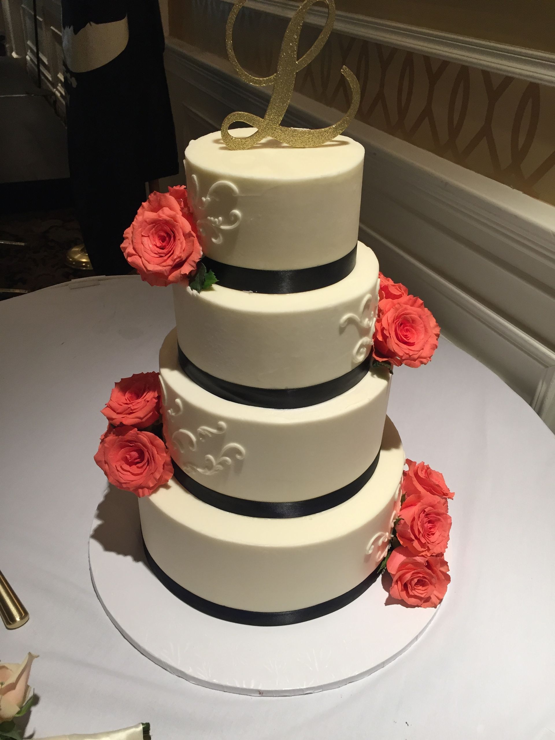 a wedding cake with the letter l on top