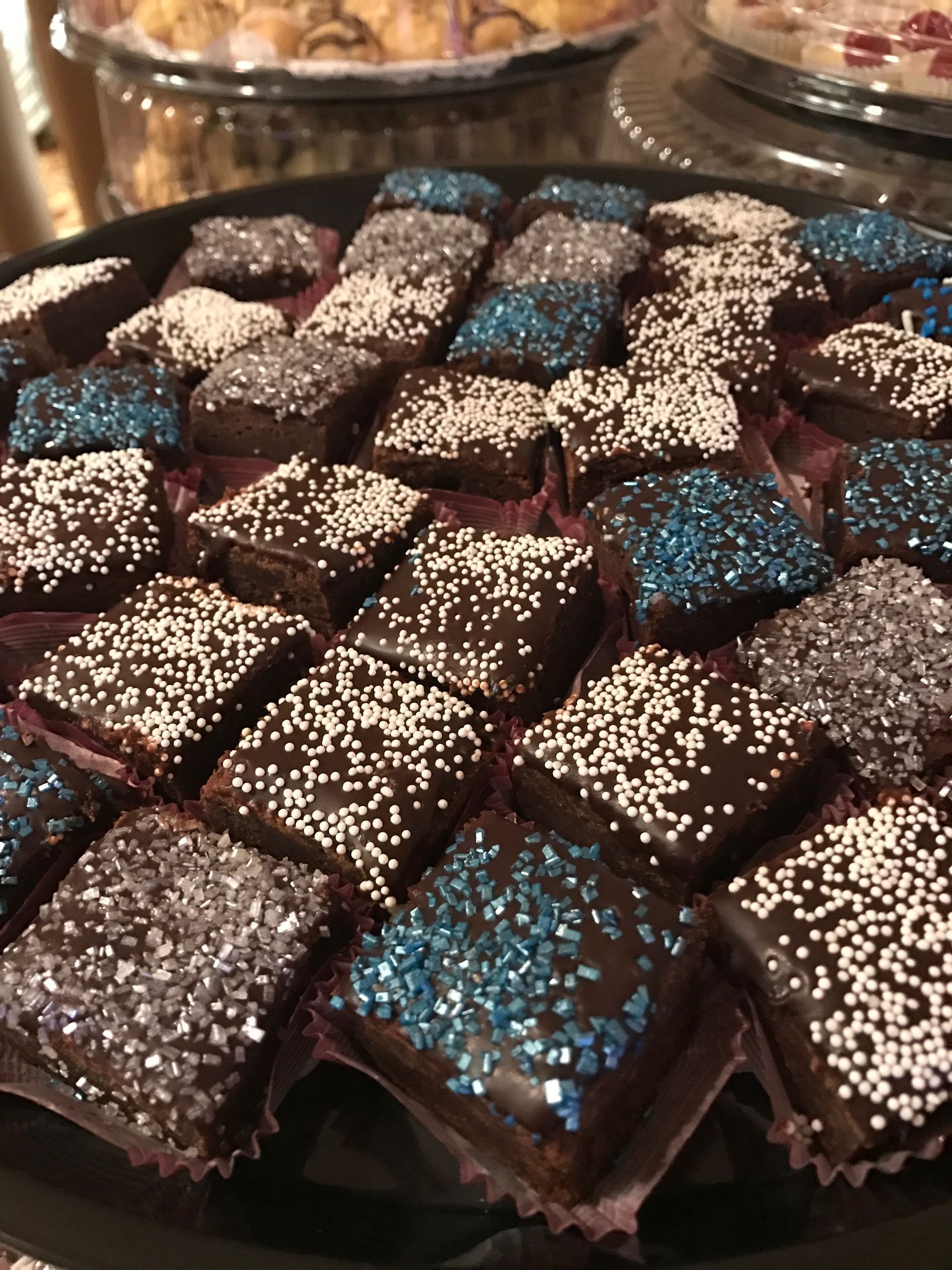 a tray of chocolate brownies with blue and white sprinkles