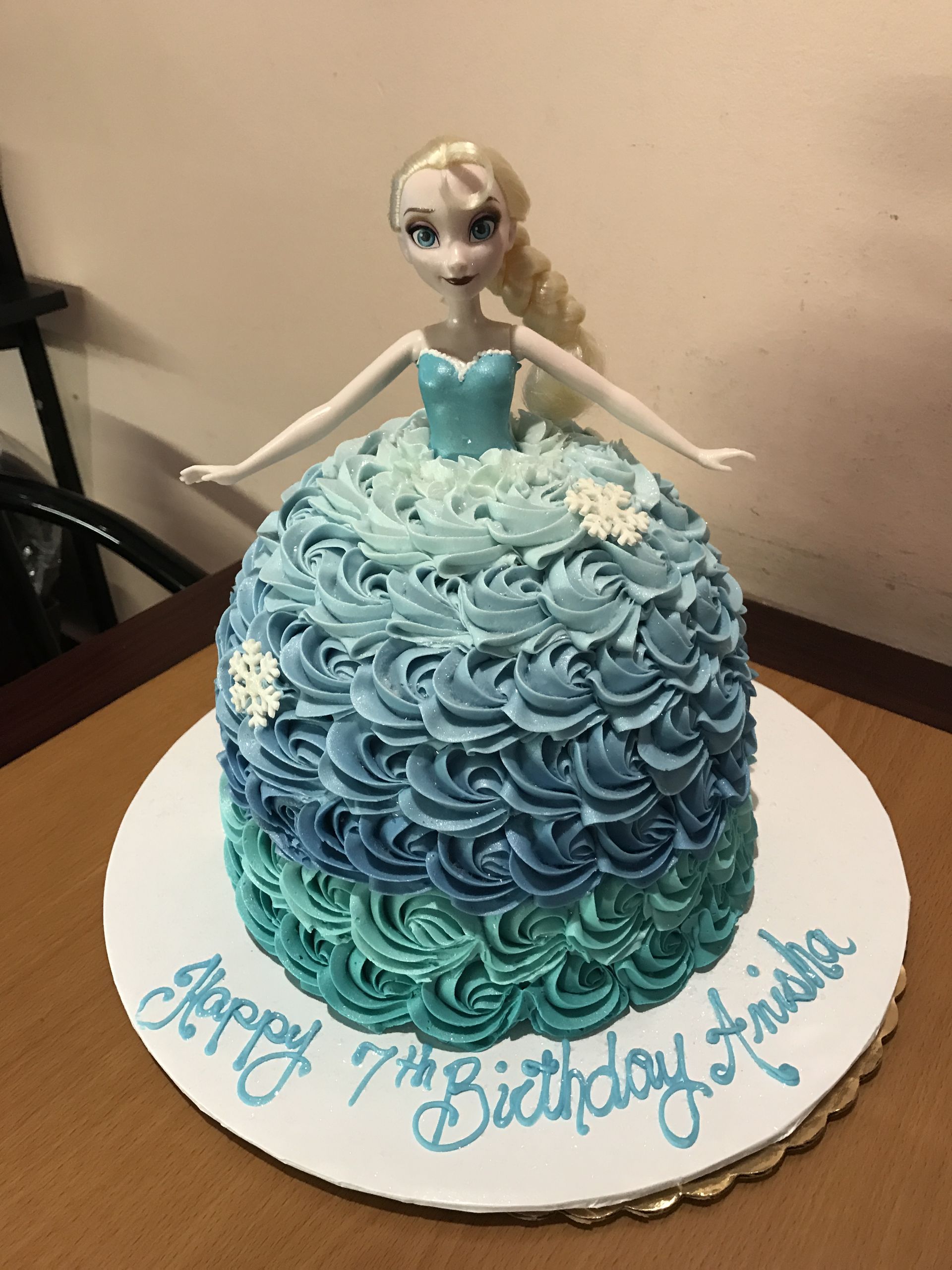 a cake with a doll on top that says happy 7th birthday
