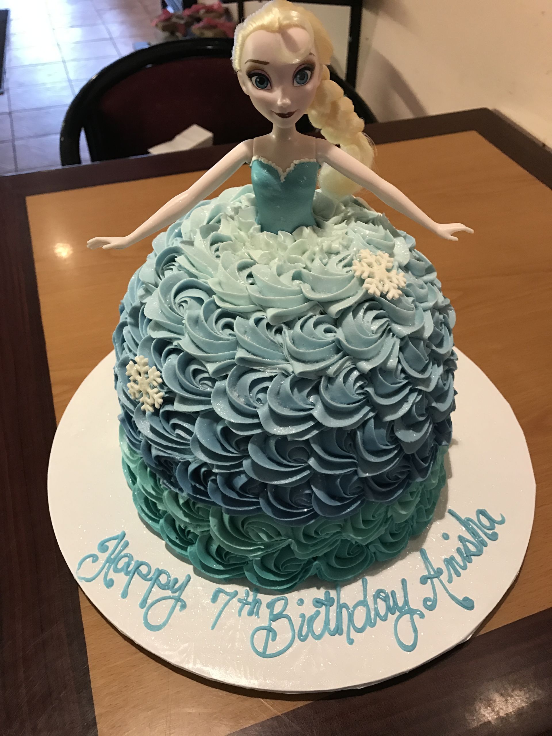 a cake with a doll on it that says happy 7th birthday