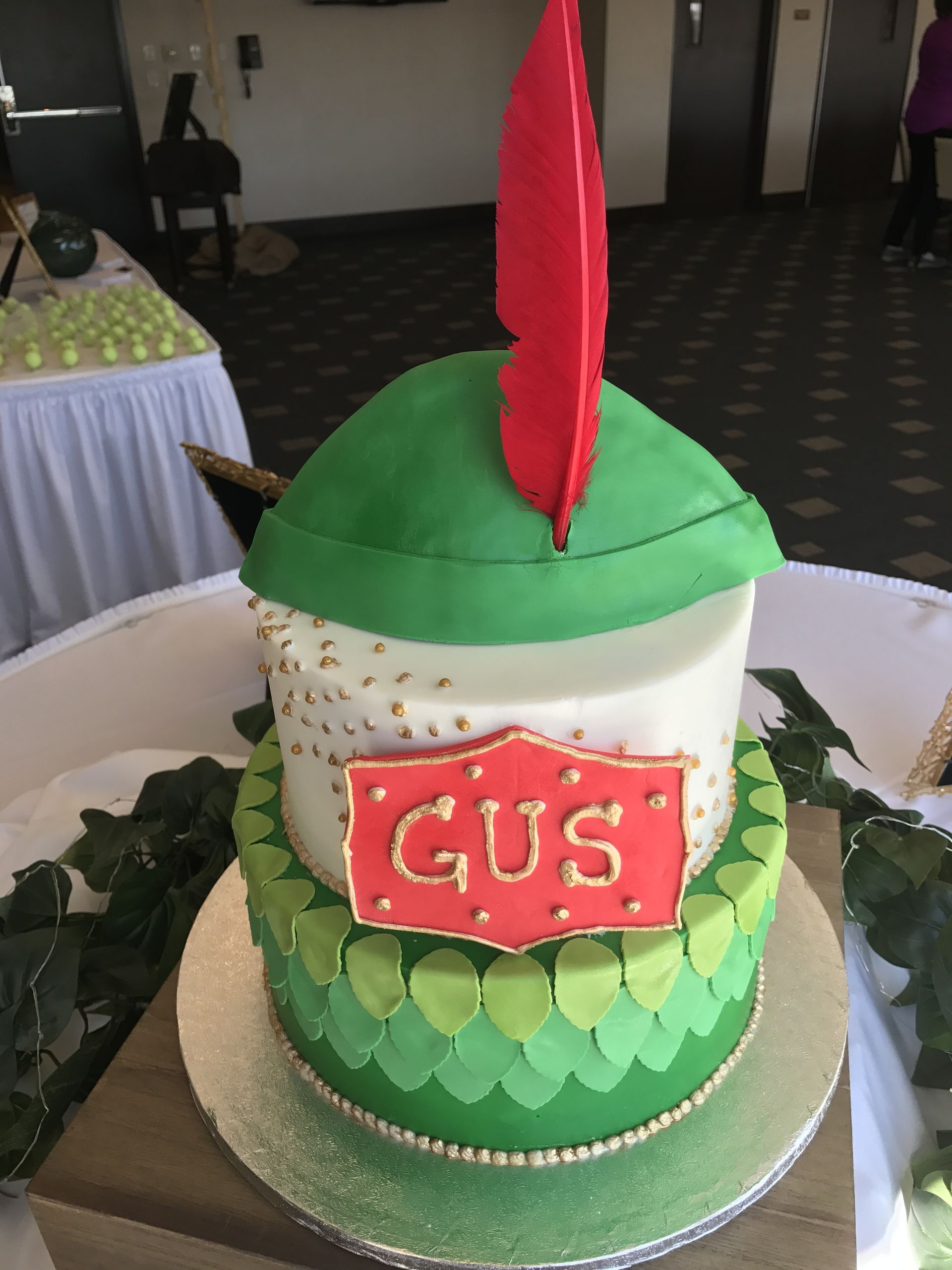a green and white cake with gus written on it