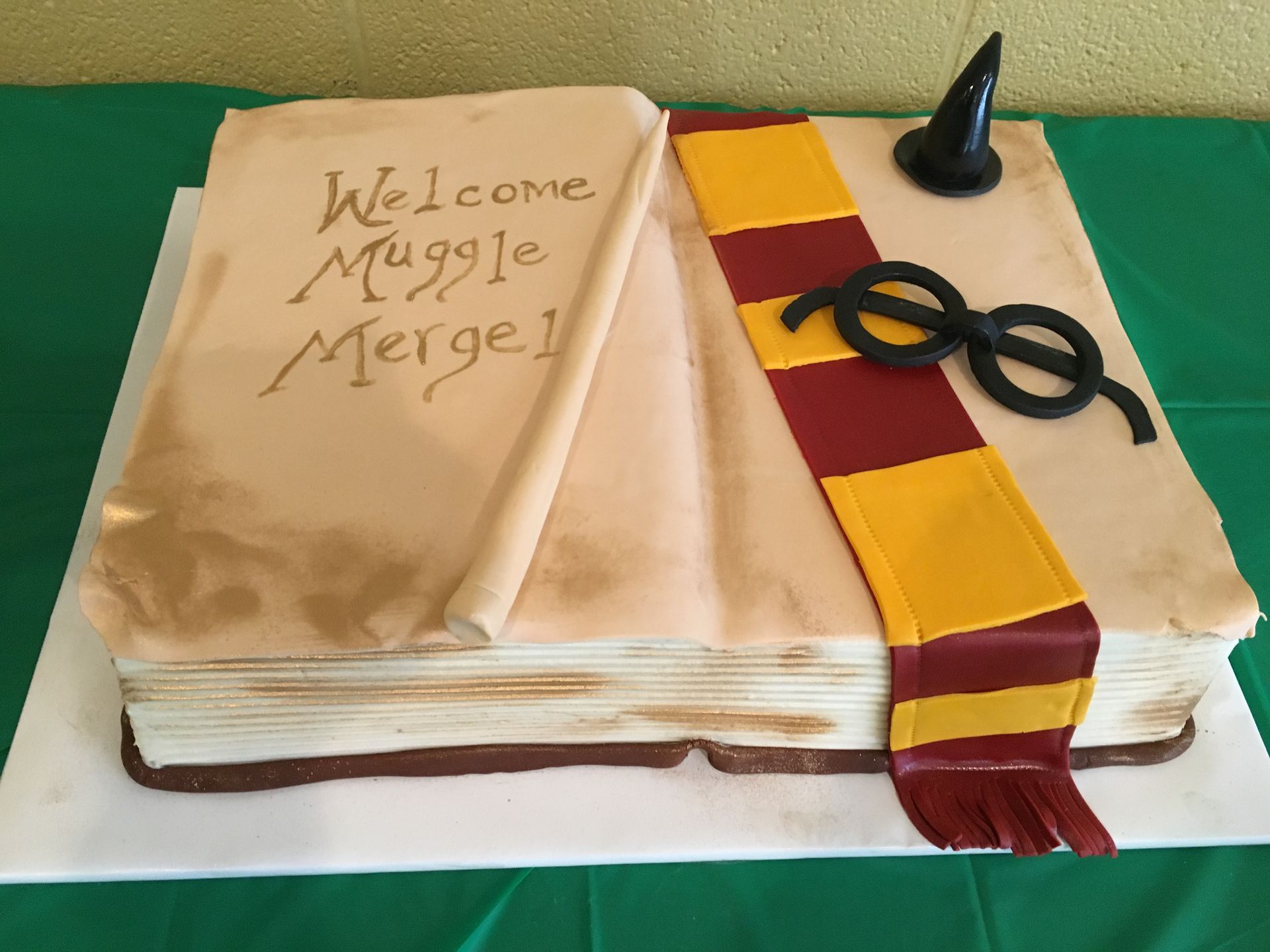 a cake that looks like a book with the words welcome muggle merge written on it