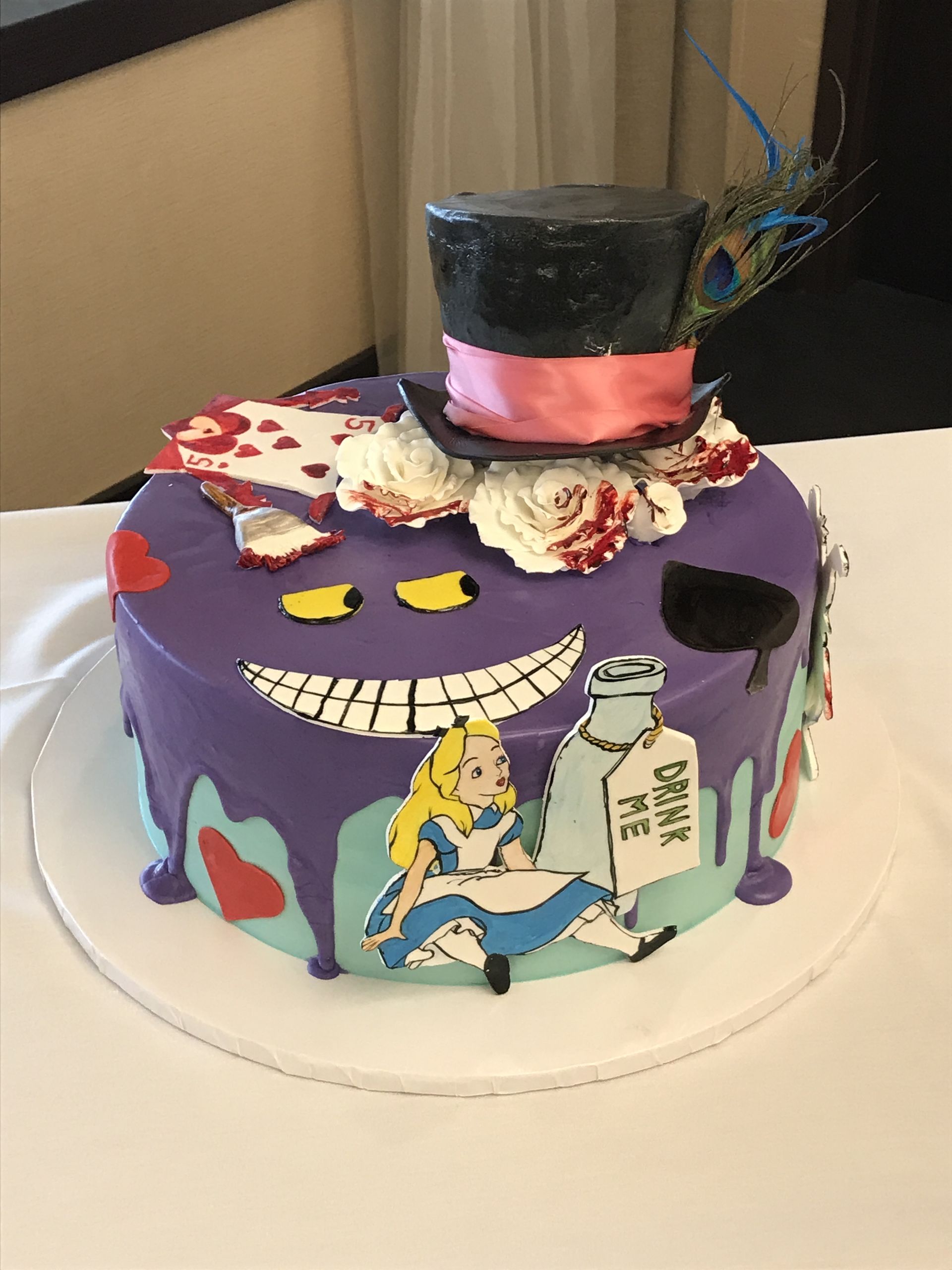 a purple alice in wonderland cake with a top hat on it