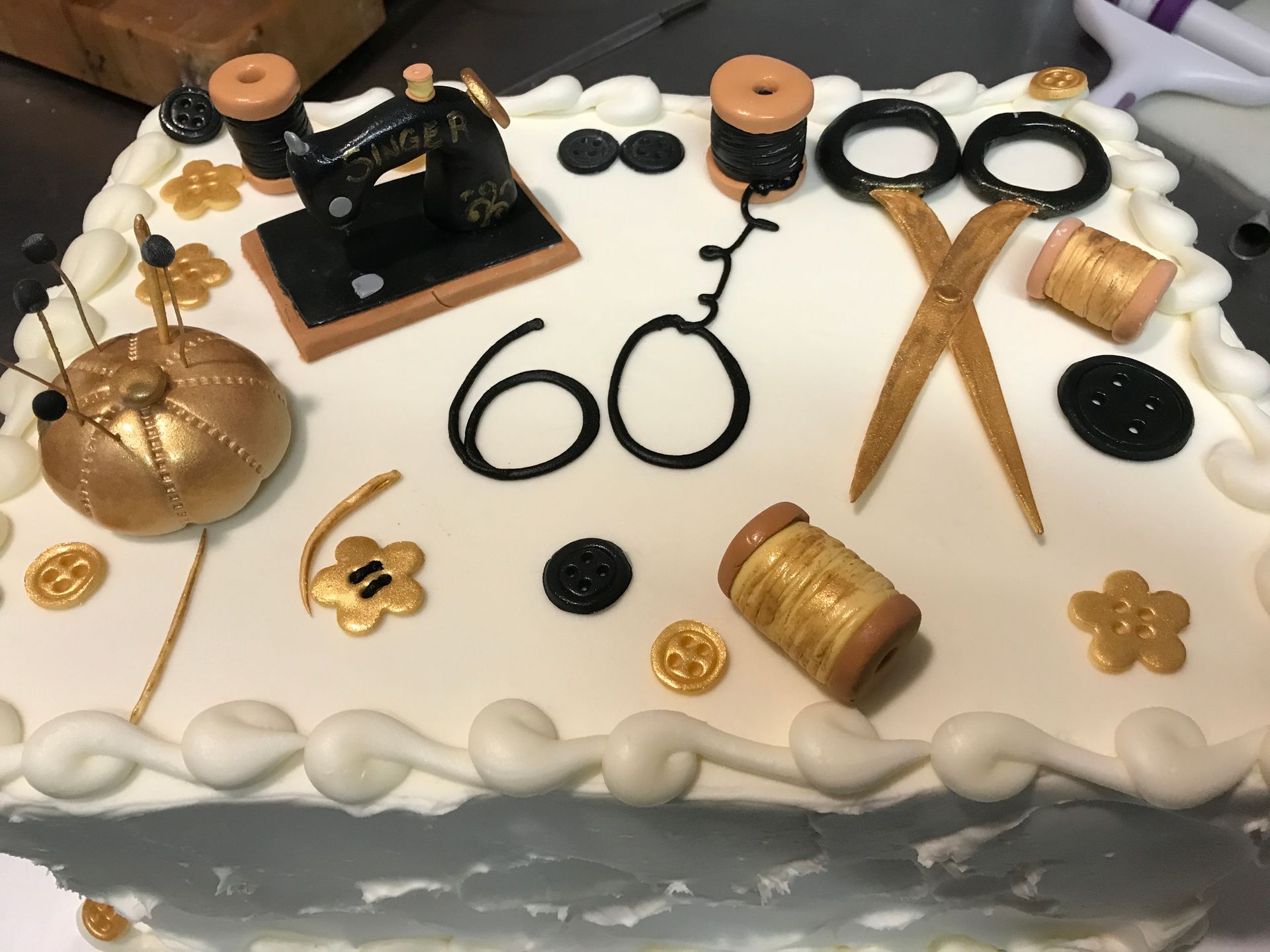 a cake with a sewing machine and scissors on it