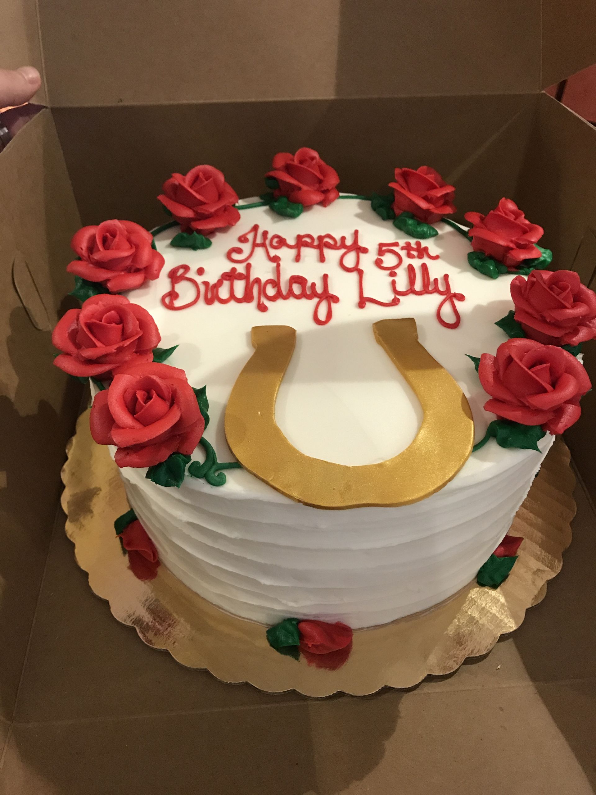 a birthday cake with red roses and a horseshoe on it
