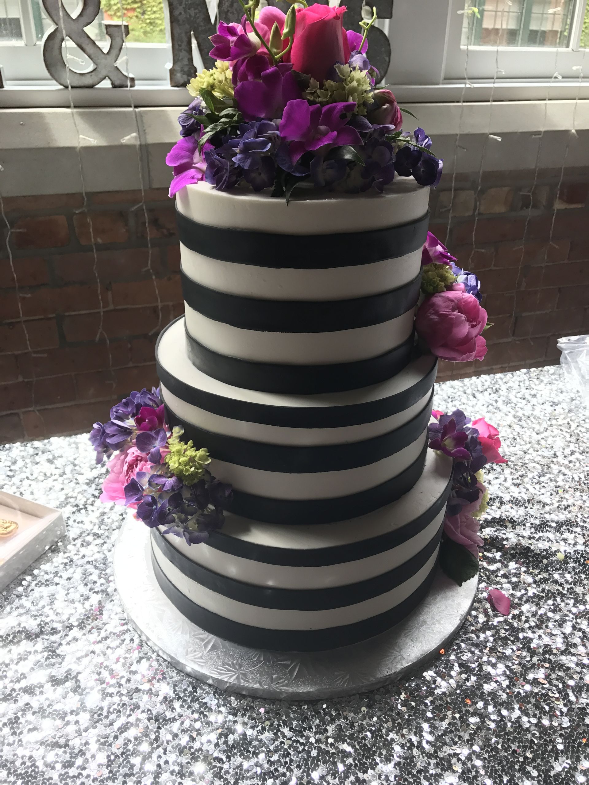 a black and white striped cake with purple flowers on top
