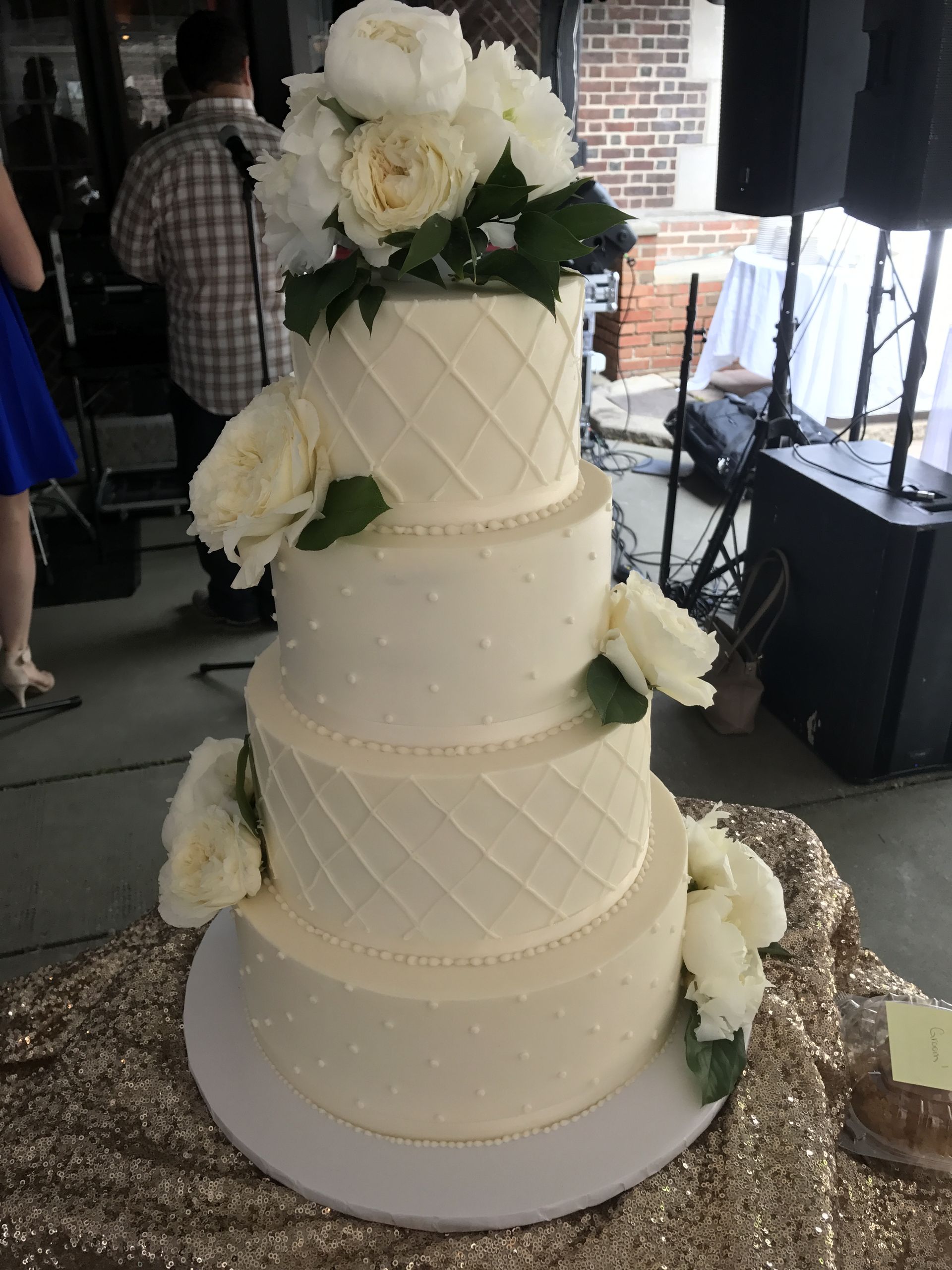 a white wedding cake with white flowers on top is sitting on a table .