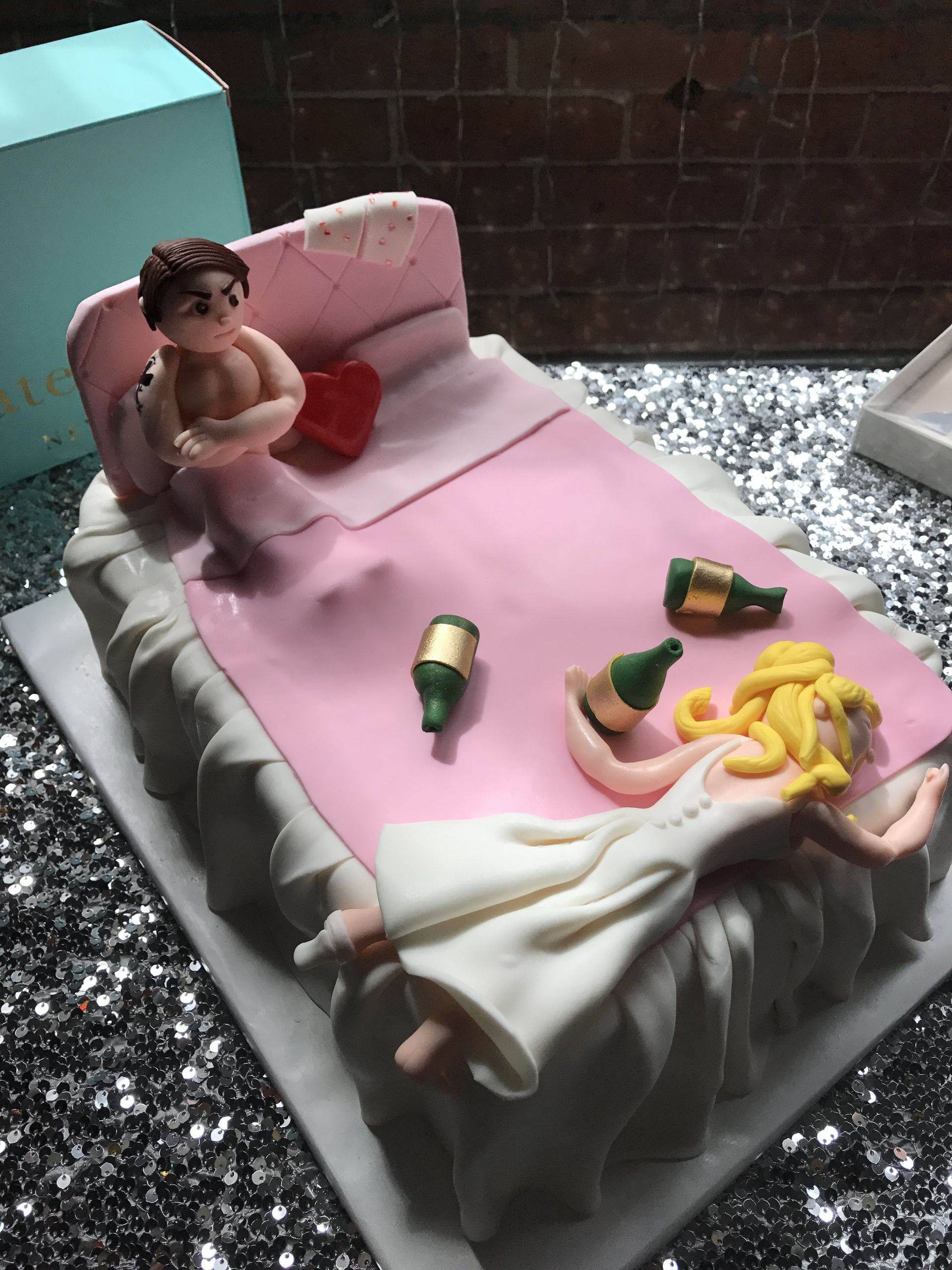a cake with a man and a woman laying on a bed