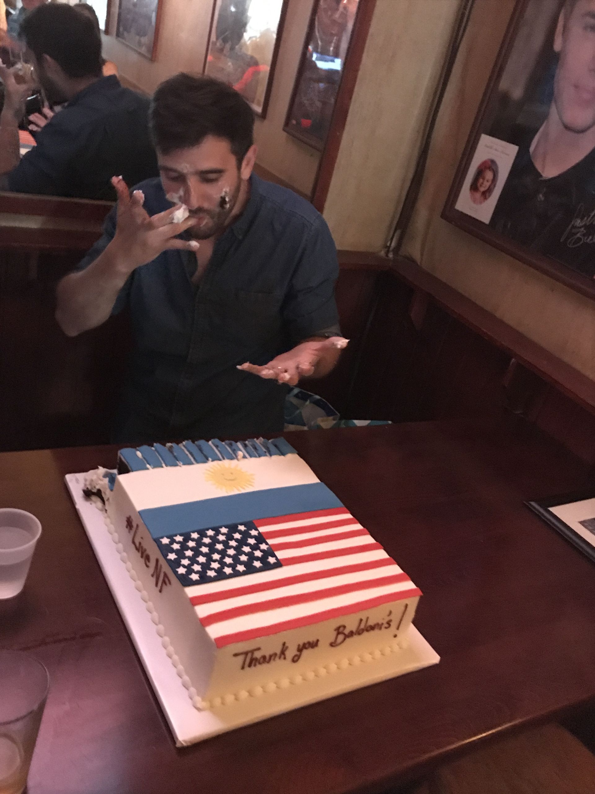 a man is sitting at a table with a cake that says thank you
