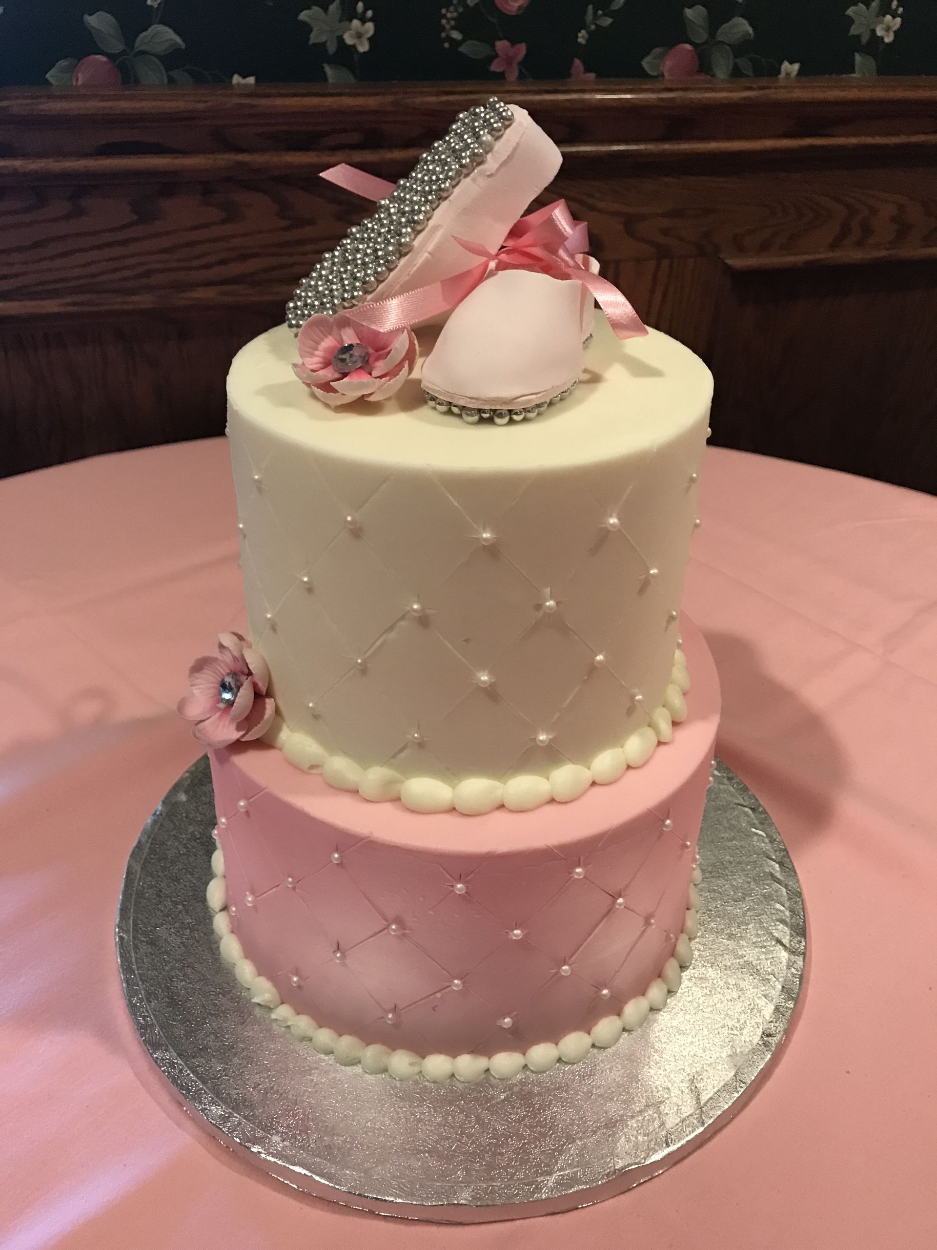 a pink and white cake with a shoe on top
