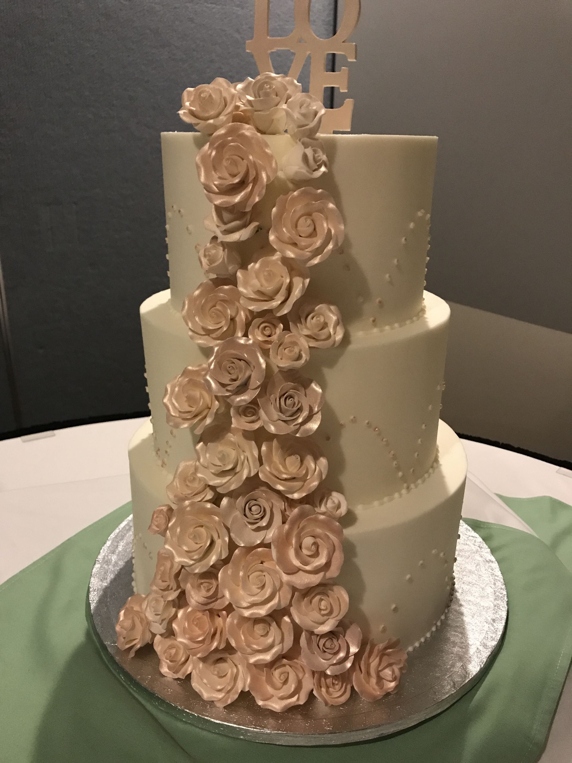 a three tiered wedding cake with roses on it